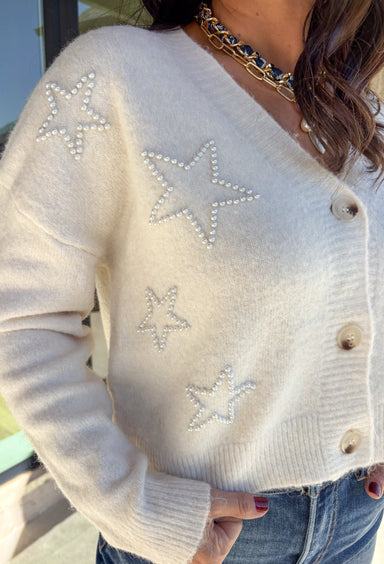 Shine bright this season in this off-white button-down cardigan by Debut. Crafted from a soft, cozy knit, this sweater features delicate pearl star embellishments that add the perfect hint of glam. With its relaxed fit and timeless charm, it’s a dreamy layer for holiday gatherings or casual winter days.
