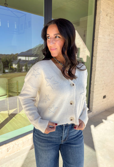 Shine bright this season in this off-white button-down cardigan by Debut. Crafted from a soft, cozy knit, this sweater features delicate pearl star embellishments that add the perfect hint of glam. With its relaxed fit and timeless charm, it’s a dreamy layer for holiday gatherings or casual winter days.