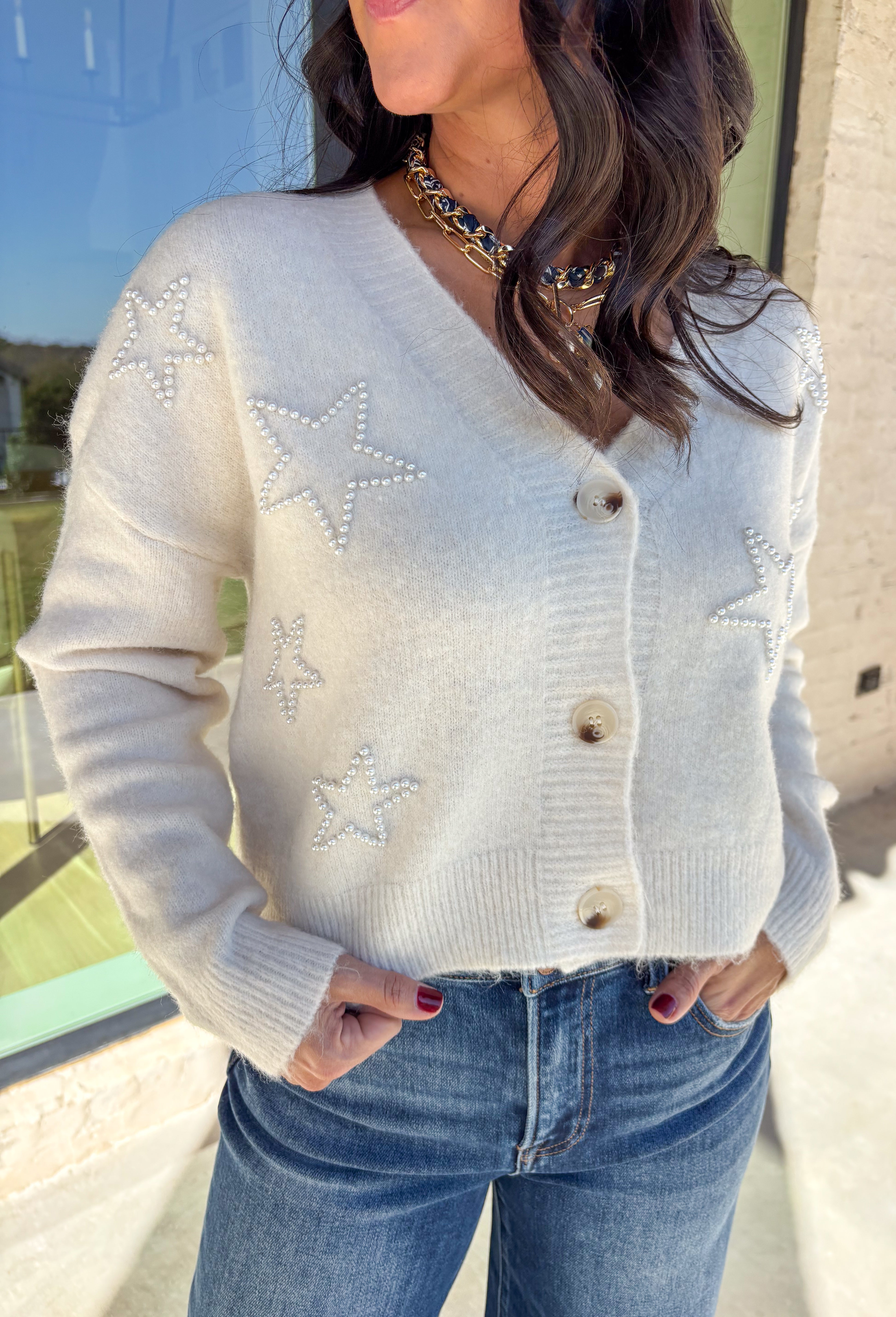 Shine bright this season in this off-white button-down cardigan by Debut. Crafted from a soft, cozy knit, this sweater features delicate pearl star embellishments that add the perfect hint of glam. With its relaxed fit and timeless charm, it’s a dreamy layer for holiday gatherings or casual winter days.
