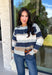Wrap yourself in cozy comfort with this timeless cardigan from Mable. Designed in a soft gray knit with classic navy, tan, and cream stripes, this sweater is the perfect layering piece for crisp fall days. The button-front design makes it easy to wear open or closed, while the ribbed neckline, hem, and cuffs add a polished finishing touch. Crafted from an ultra-soft knit blend, this cardigan is perfect for everything from relaxing weekends to coffee dates and casual workdays.