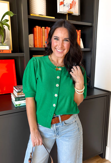 Soft, happy, and perfect for spring layering, this green button-down knit top by Entro brings a pop of color to your everyday wardrobe. The lightweight knit feels cozy without being heavy, making it ideal for those in-between spring days. Ribbed detailing along the neckline, cuffs, and hem adds subtle texture and a polished finish, while the button-down design makes it easy to wear on its own or layered over a tank.