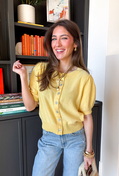 Soft, sunny, and perfect for spring layering, this butter yellow button-down knit top by Entro brings a warm pop of color to your everyday wardrobe. The lightweight knit feels cozy without being heavy, making it ideal for those in-between spring days. Ribbed detailing along the neckline, cuffs, and hem adds subtle texture and a polished finish, while the button-down design makes it easy to wear on its own or layered over a tank.