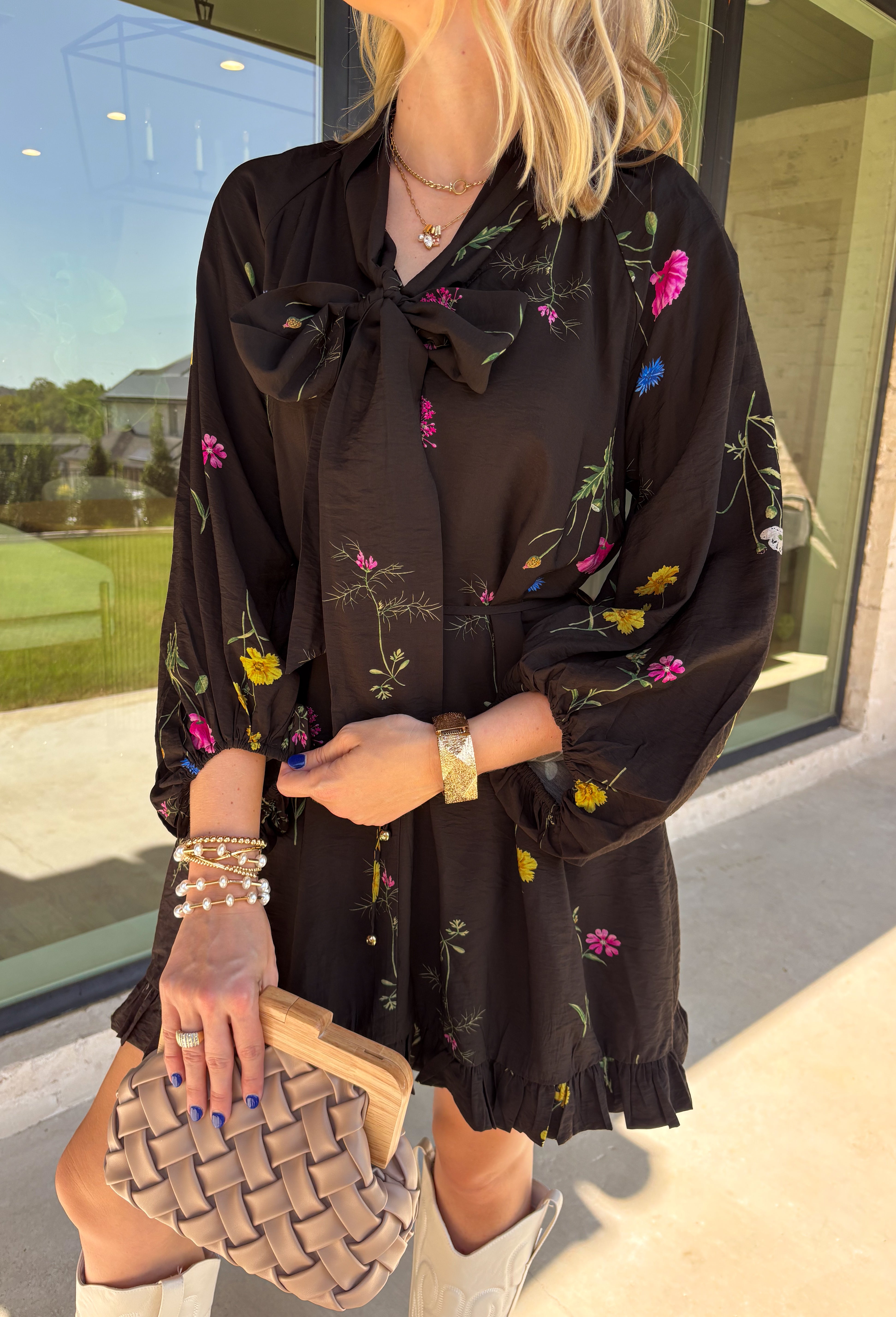 Feminine, chic, and full of seasonal charm, this floral dress is the perfect piece for all your favorite fall occasions. Featuring a classic black backdrop with a vibrant colorful floral print, this dress offers a timeless silhouette with eye-catching details. The flattering v-neckline is accented by a beautiful scarf tie that adds a polished, sophisticated touch, while the self-tie waist creates a customizable fit you'll love. 