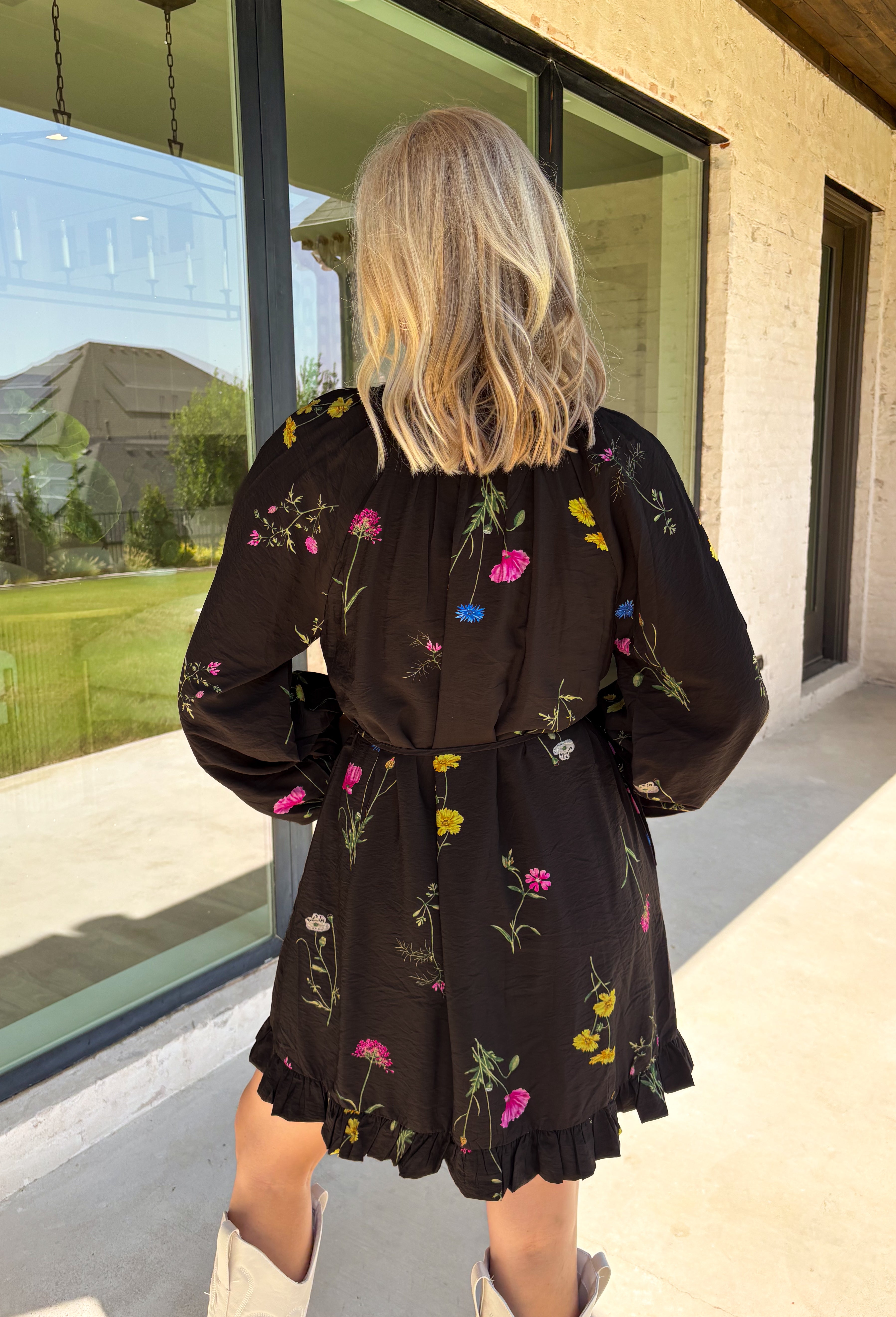 Feminine, chic, and full of seasonal charm, this floral dress is the perfect piece for all your favorite fall occasions. Featuring a classic black backdrop with a vibrant colorful floral print, this dress offers a timeless silhouette with eye-catching details. The flattering v-neckline is accented by a beautiful scarf tie that adds a polished, sophisticated touch, while the self-tie waist creates a customizable fit you'll love. 