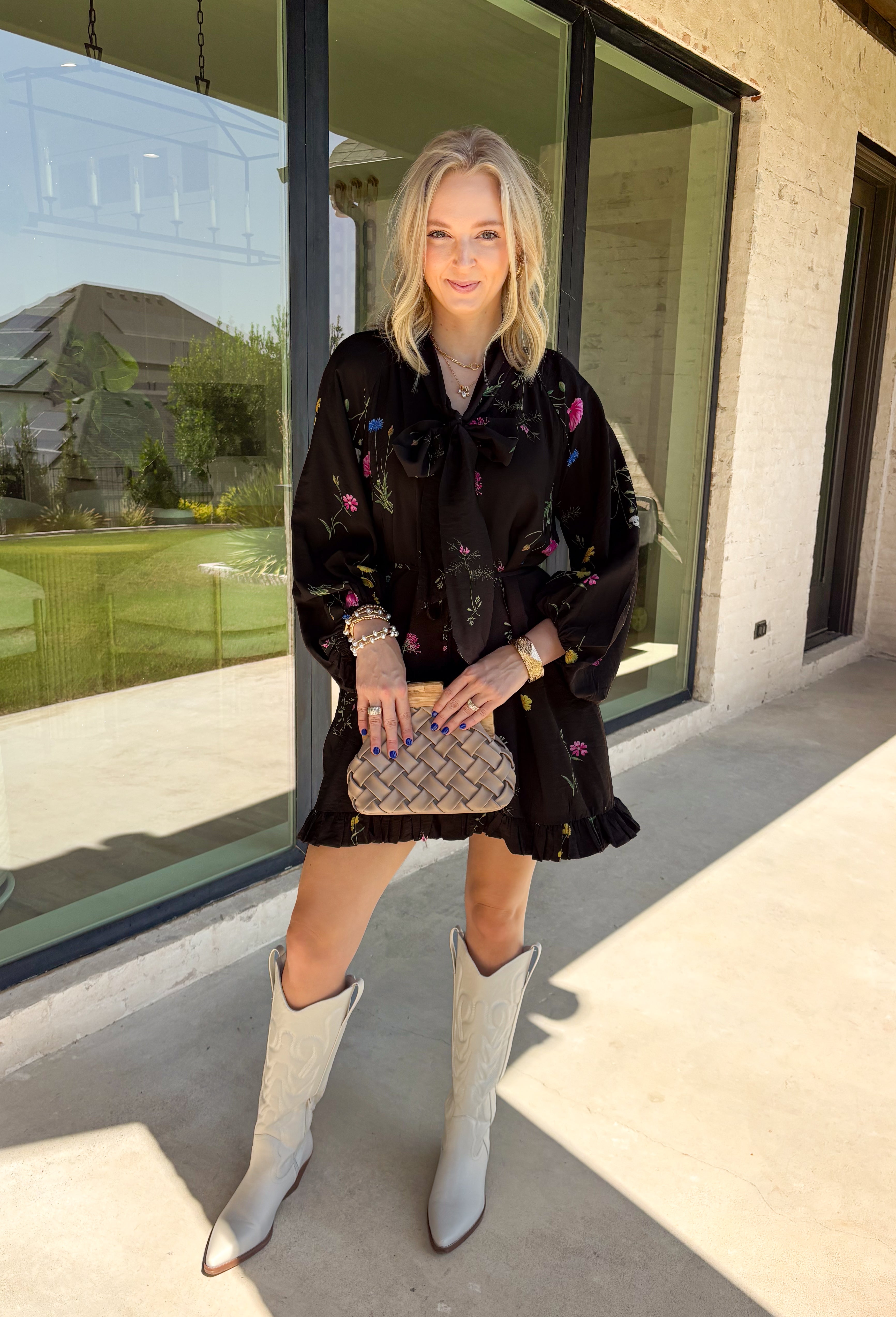 Feminine, chic, and full of seasonal charm, this floral dress is the perfect piece for all your favorite fall occasions. Featuring a classic black backdrop with a vibrant colorful floral print, this dress offers a timeless silhouette with eye-catching details. The flattering v-neckline is accented by a beautiful scarf tie that adds a polished, sophisticated touch, while the self-tie waist creates a customizable fit you'll love. 