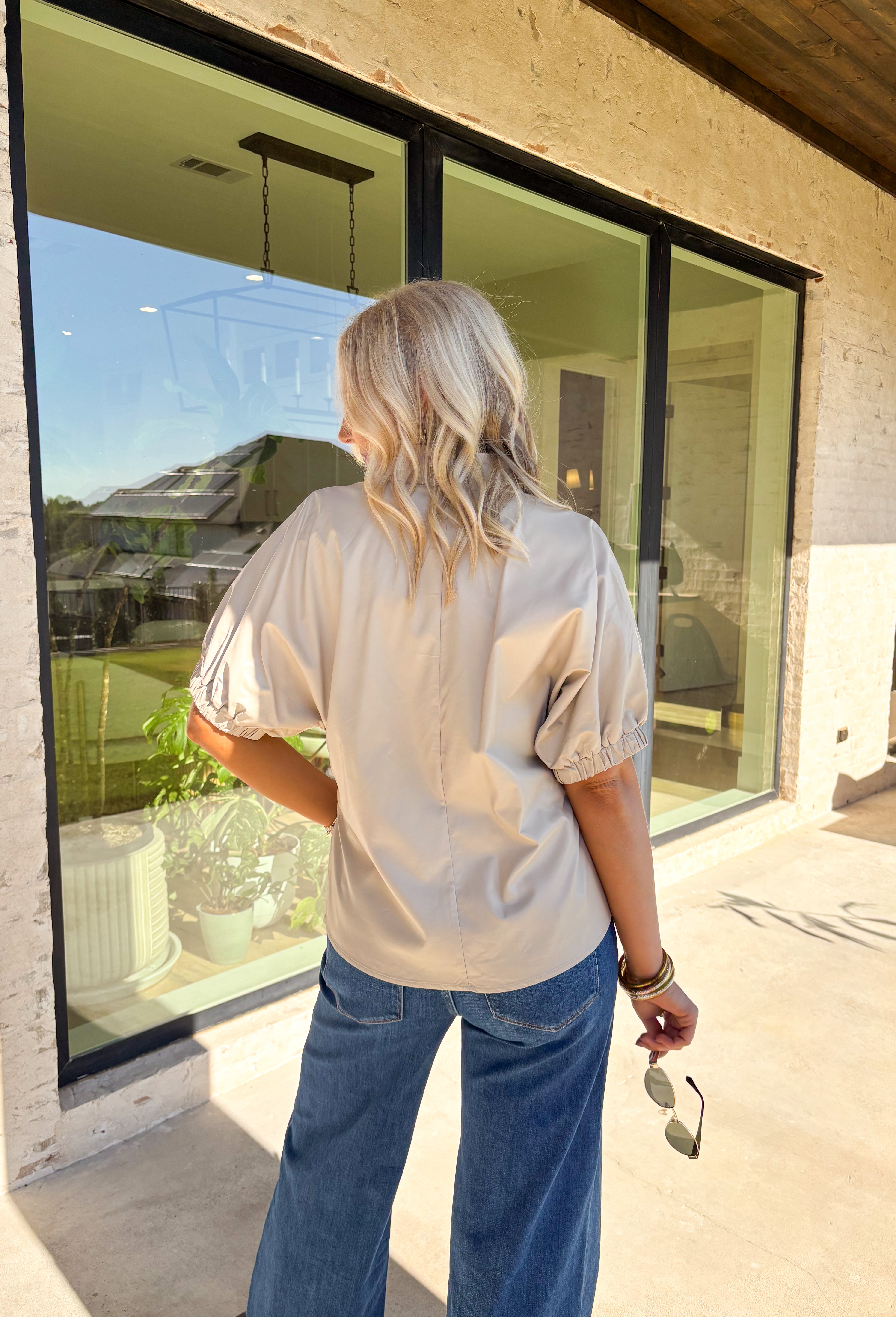 Elevate your wardrobe with this chic ecru faux leather top by Entro. Designed with short puff sleeves and elasticated openings, it strikes the perfect balance of structured and feminine. The split v-neckline with a stand collar adds a modern edge, while the soft faux leather finish brings a touch of texture that feels fresh for the season. Perfect for dressing up denim or pairing with skirts, this top is a statement piece you’ll reach for again and again.