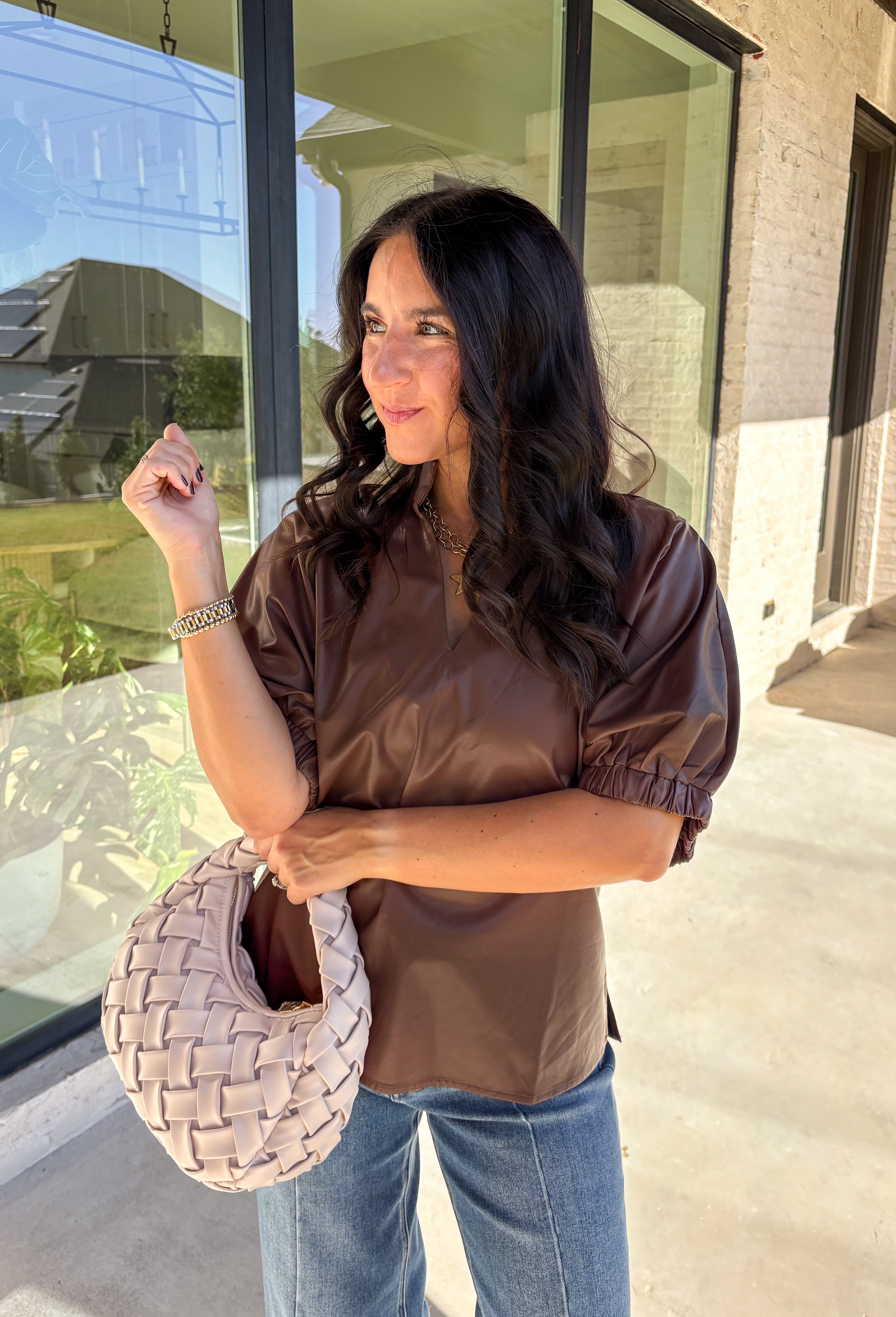 Elevate your wardrobe with this chic brown faux leather top by Entro. Designed with short puff sleeves and elasticated openings, it strikes the perfect balance of structured and feminine. The split v-neckline with a stand collar adds a modern edge, while the soft faux leather finish brings a touch of texture that feels fresh for the season. Perfect for dressing up denim or pairing with skirts, this top is a statement piece you’ll reach for again and again.