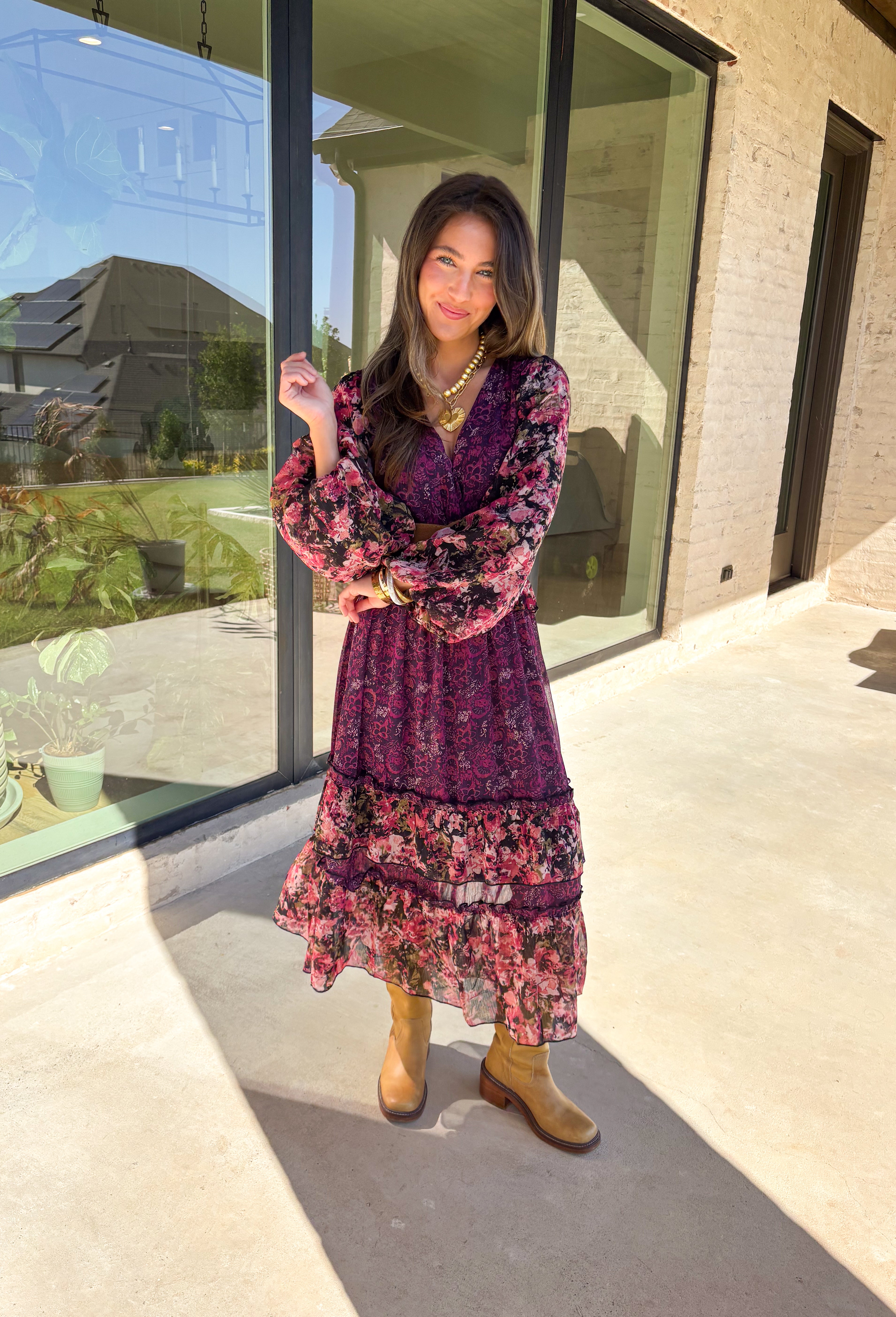 Romantic and striking, this midi dress by Mystree is full of seasonal charm. Crafted in a rich dark purple with a monochromatic floral print, it’s accented by black sleeves featuring a pink floral pattern for a chic contrast. The same floral design is carried through with delicate ruffle detailing, while subtle gold shimmer threading adds a touch of elegance. Finished with an elastic waist and sleeves for comfort, plus a full lining, this dress is as wearable as it is eye-catching.