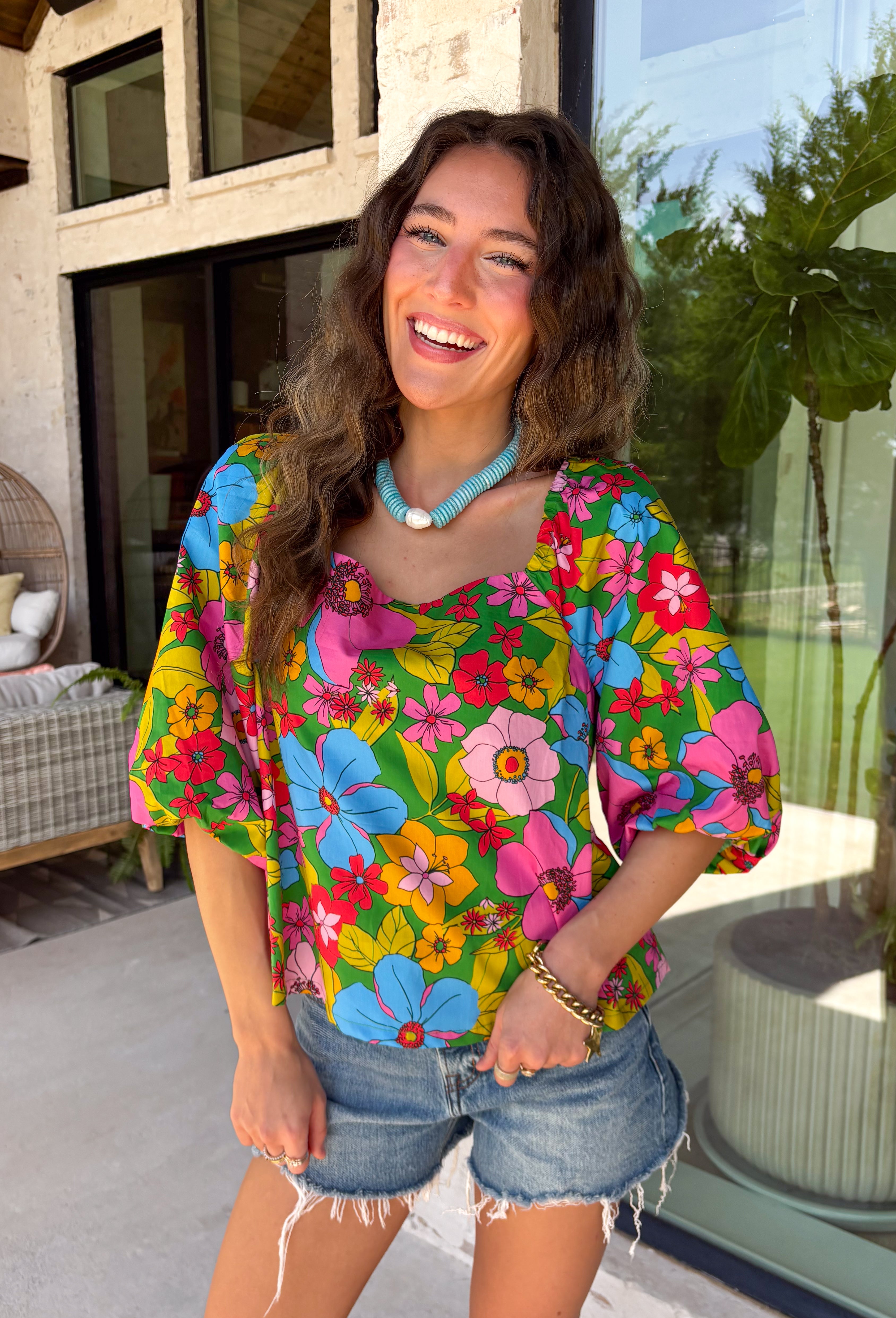 This green floral top is bursting with color and made for sunny summer days! Featuring a vibrant floral print in shades of pink, red, yellow, and blue, it instantly brightens up any outfit. The square neckline gives it a flattering, feminine feel, while the puff sleeves add just the right amount of charm. Finished with a sweet tie detail in the back, this lightweight cotton top is perfect for everything from brunch dates to weekend getaways. 