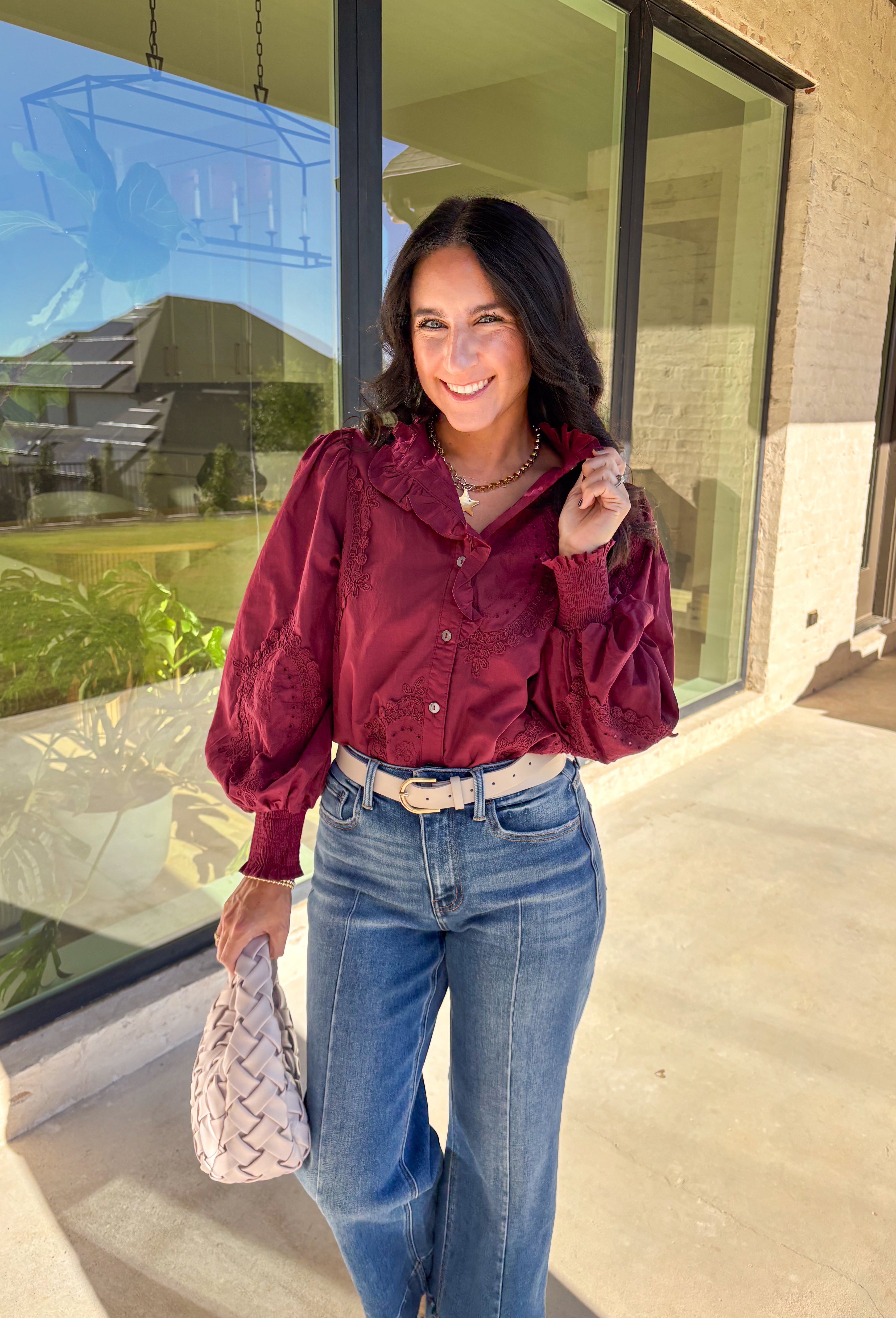 Timeless and full of detail, this burgundy top by Entro adds a refined touch to your fall wardrobe. Featuring an oval embroidered appliqué with eyelet accents, it’s beautifully designed to bring texture and depth to your look. The ruffled stand collar and smocked sleeve cuffs create a feminine finish, while the button-front closure keeps it classic and easy to style. Made from soft cotton, this top blends comfort and elegance effortlessly.
