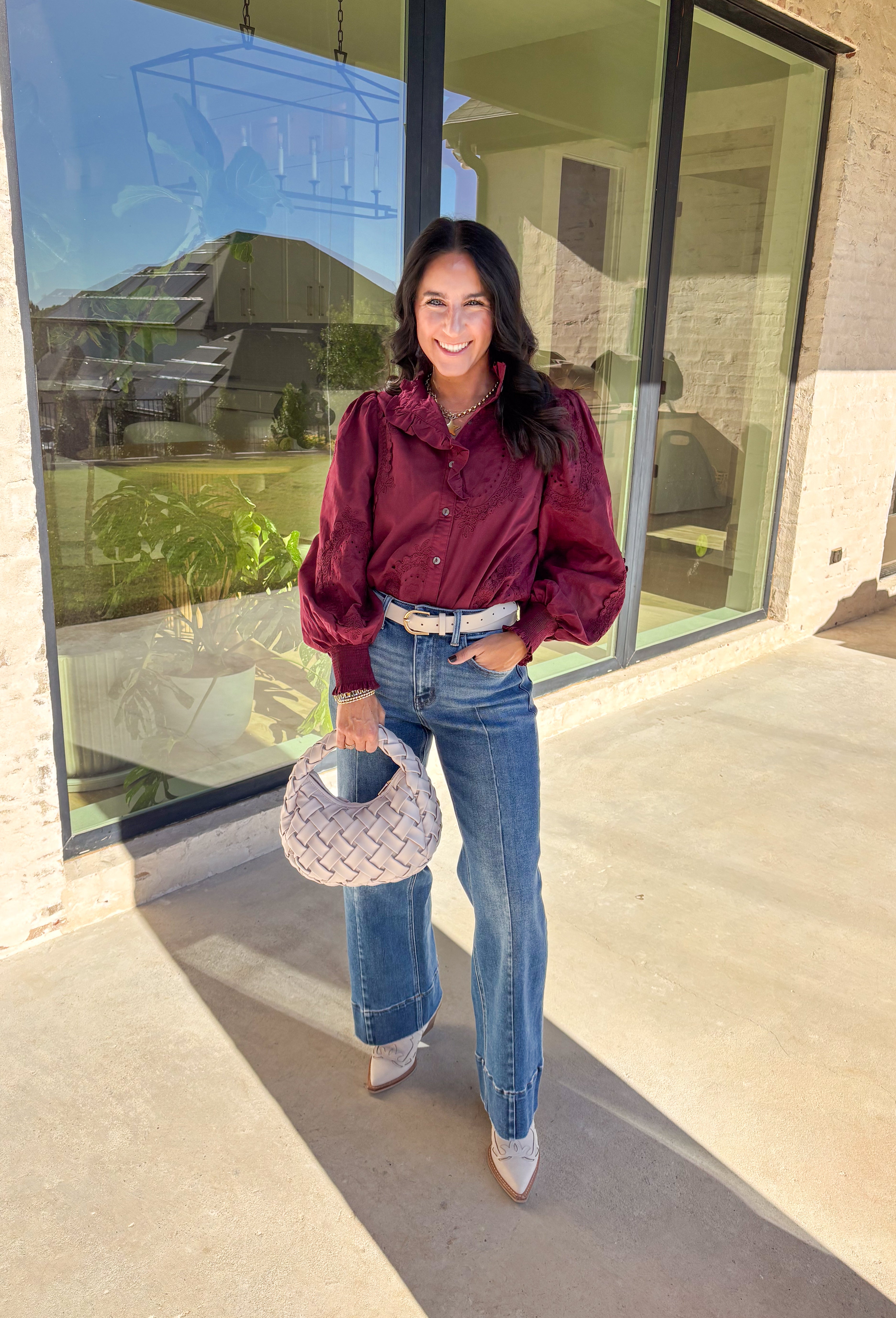 Timeless and full of detail, this burgundy top by Entro adds a refined touch to your fall wardrobe. Featuring an oval embroidered appliqué with eyelet accents, it’s beautifully designed to bring texture and depth to your look. The ruffled stand collar and smocked sleeve cuffs create a feminine finish, while the button-front closure keeps it classic and easy to style. Made from soft cotton, this top blends comfort and elegance effortlessly.
