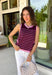 This striped sleeveless sweater is the perfect way to welcome sweater weather! Featuring rich burgundy and pink stripes, it captures all the cozy charm of the season while remaining lightweight enough for those in-between fall days. The contrast trim adds a polished finish, and the classic round neckline makes it easy to wear on its own or layered under your favorite denim jacket, blazer, or cardigan. 