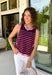 This striped sleeveless sweater is the perfect way to welcome sweater weather! Featuring rich burgundy and pink stripes, it captures all the cozy charm of the season while remaining lightweight enough for those in-between fall days. The contrast trim adds a polished finish, and the classic round neckline makes it easy to wear on its own or layered under your favorite denim jacket, blazer, or cardigan. 
