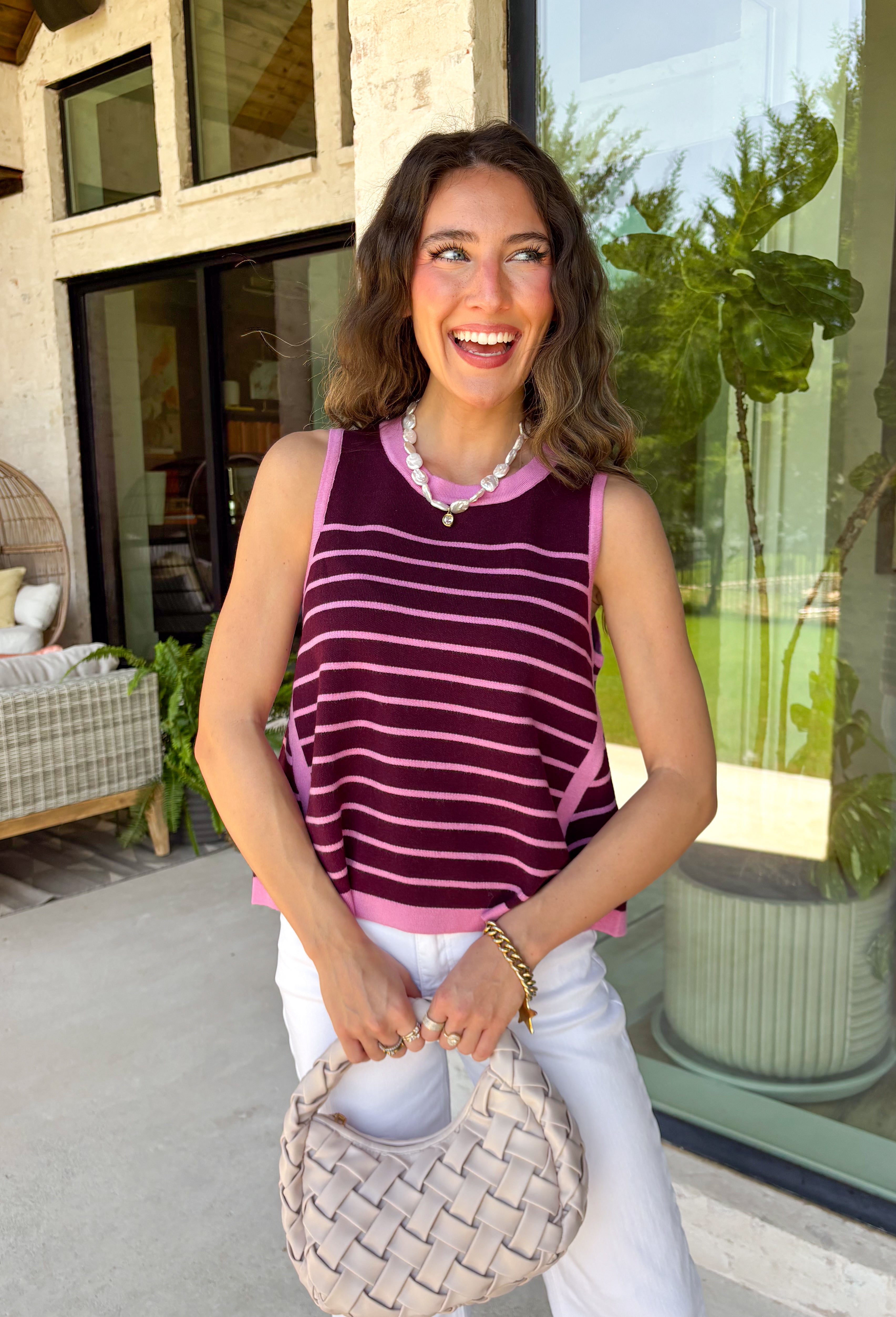 This striped sleeveless sweater is the perfect way to welcome sweater weather! Featuring rich burgundy and pink stripes, it captures all the cozy charm of the season while remaining lightweight enough for those in-between fall days. The contrast trim adds a polished finish, and the classic round neckline makes it easy to wear on its own or layered under your favorite denim jacket, blazer, or cardigan. 
