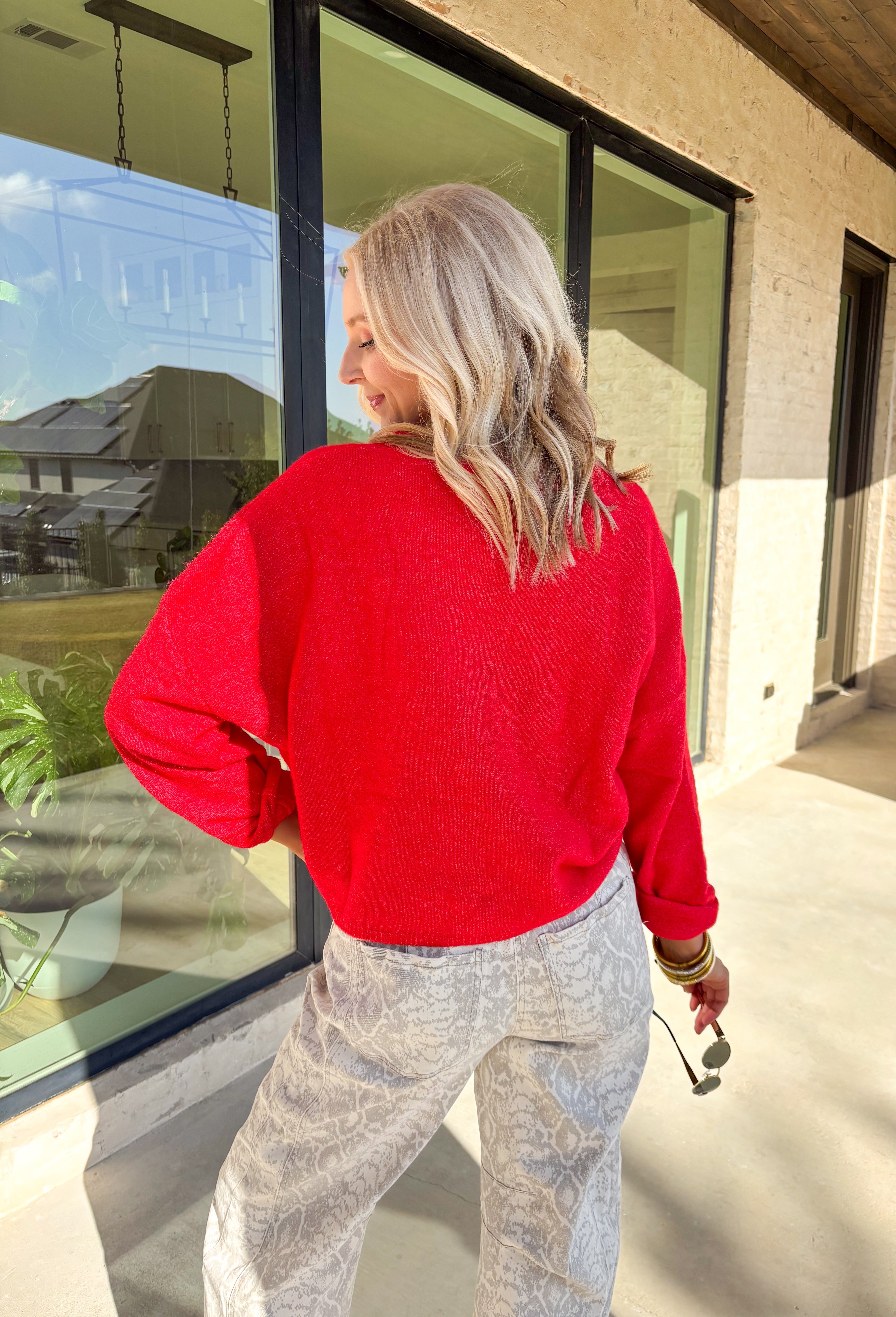 Wrap yourself in cozy holiday charm with this classic red cardigan by Things Between. Featuring a soft knit texture and timeless button-down design, this piece is perfect for layering through the festive season. Its rich red hue makes it a cheerful go-to for holiday gatherings, cozy nights in, or a casual winter day out.