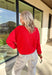 Wrap yourself in cozy holiday charm with this classic red cardigan by Things Between. Featuring a soft knit texture and timeless button-down design, this piece is perfect for layering through the festive season. Its rich red hue makes it a cheerful go-to for holiday gatherings, cozy nights in, or a casual winter day out.