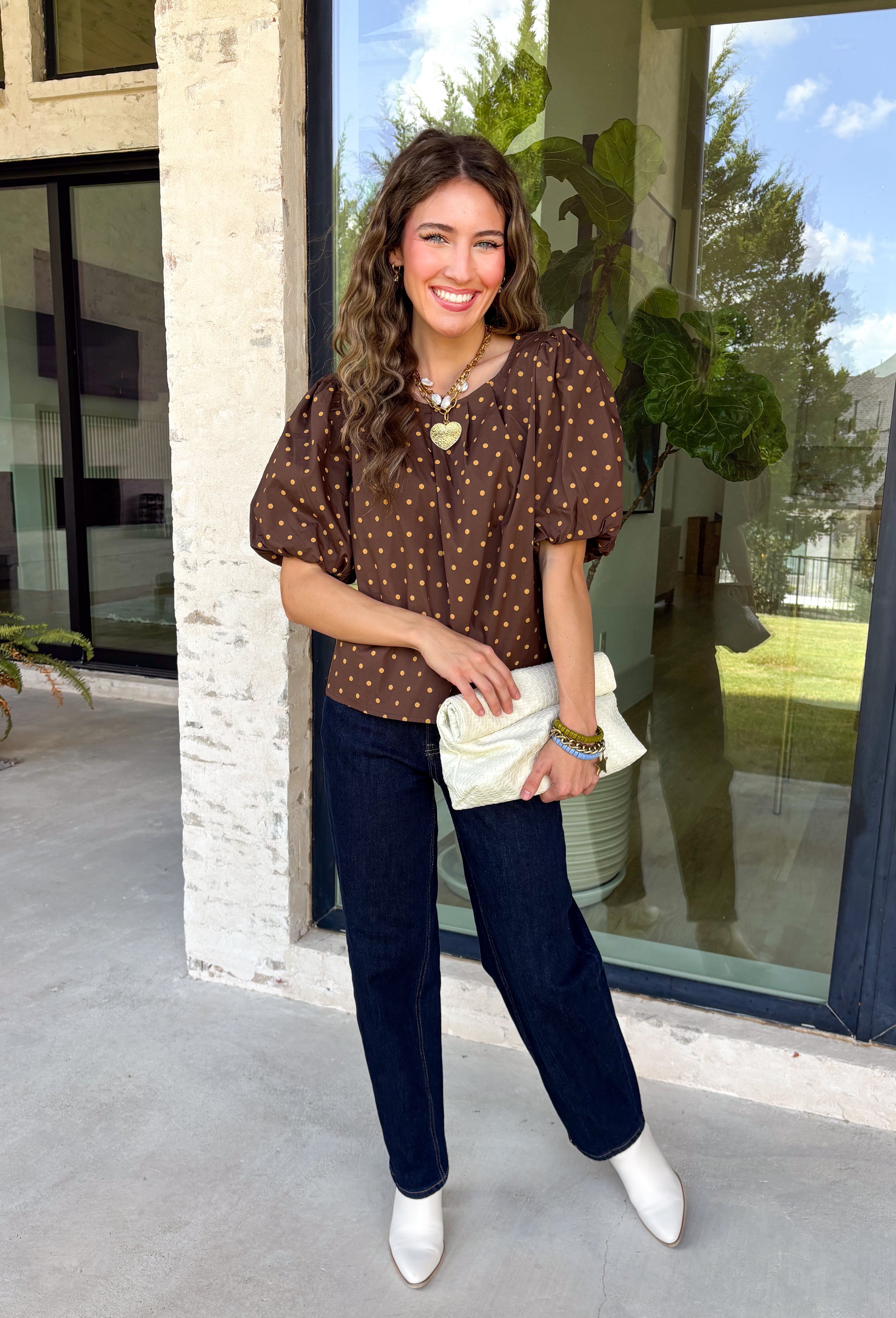 Classic polka dots never go out of style, and this charming top from Day + Moon is the perfect addition to your fall wardrobe. Designed in a rich brown hue with a timeless tan polka dot print, this effortlessly feminine blouse is easy to dress up or down. The puff sleeves add a soft, romantic touch, while the keyhole button closure at the back creates a polished finishing detail. Crafted from breathable cotton, this versatile top is perfect for everything from workdays to weekend outings.