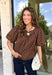 Classic polka dots never go out of style, and this charming top from Day + Moon is the perfect addition to your fall wardrobe. Designed in a rich brown hue with a timeless tan polka dot print, this effortlessly feminine blouse is easy to dress up or down. The puff sleeves add a soft, romantic touch, while the keyhole button closure at the back creates a polished finishing detail. Crafted from breathable cotton, this versatile top is perfect for everything from workdays to weekend outings.