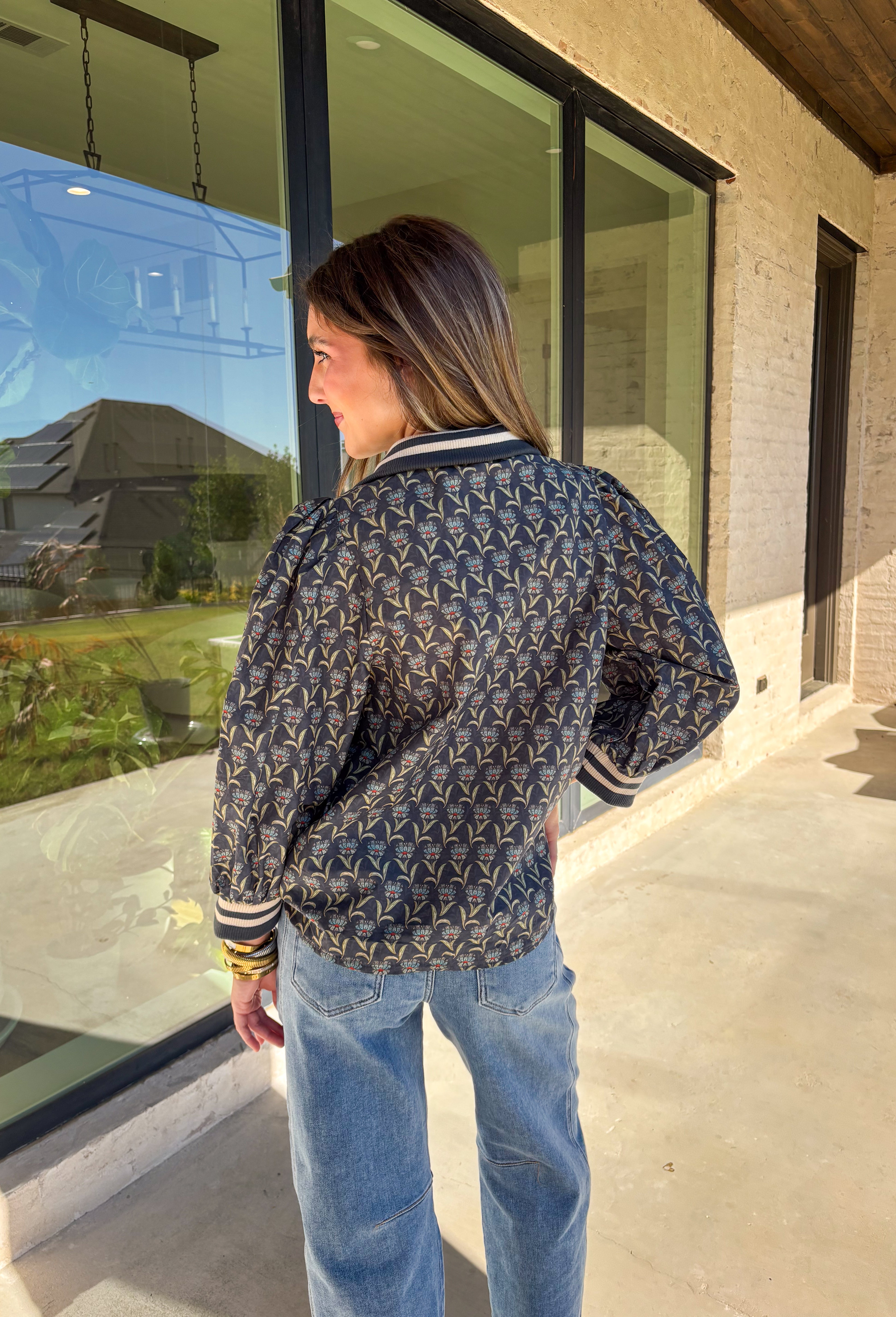 This midnight floral top by Entro is the perfect blend of casual comfort and standout style. Featuring ¾ puff sleeves and a sporty contrast ribbed stand collar and cuffs, it adds a playful edge to the feminine floral print. Shades of green and blue give it a cool, seasonal vibe, while the half zip front closure adds a touch of versatility. Made from 100% cotton, it’s lightweight, breathable, and perfect for transitional weather.