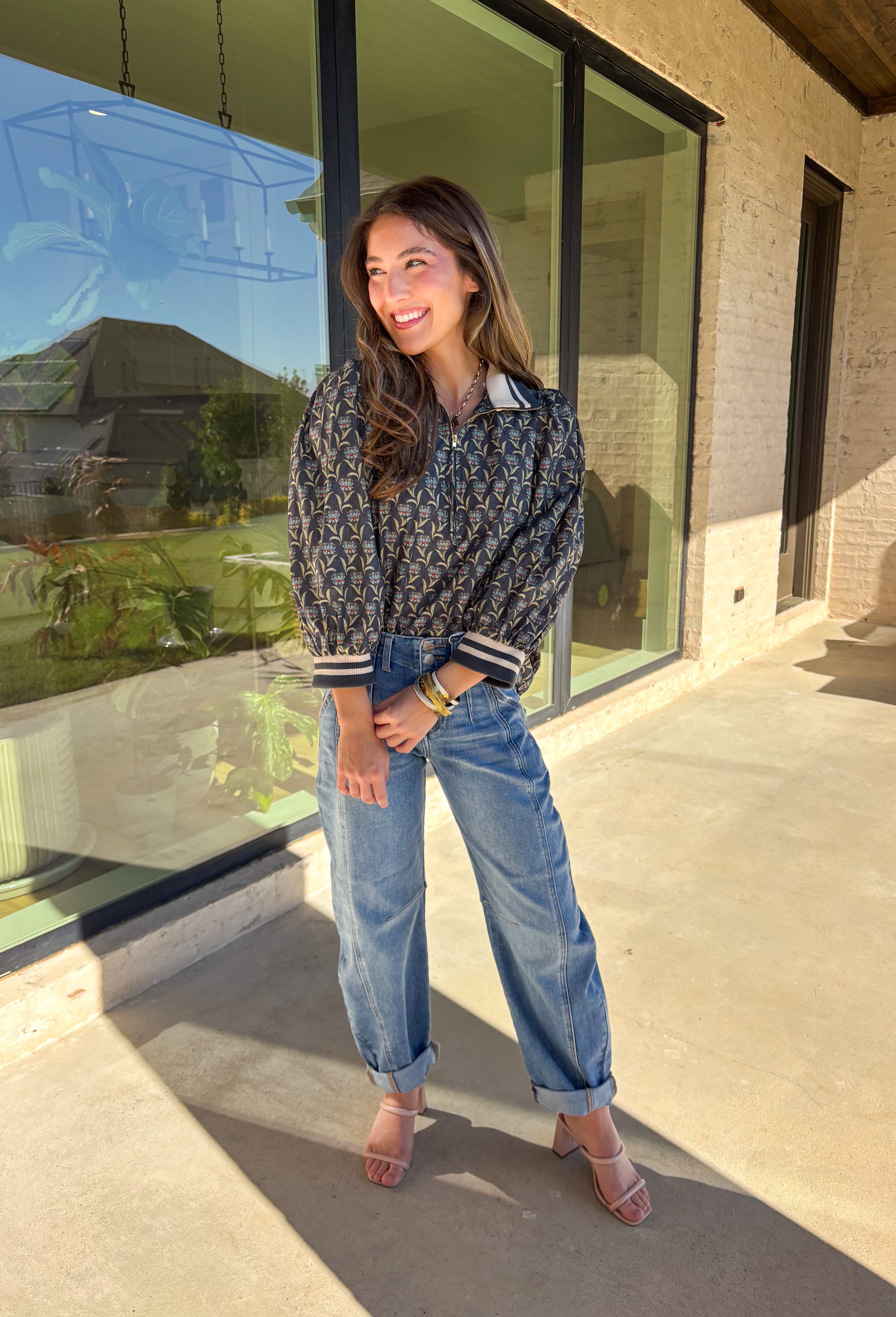 This midnight floral top by Entro is the perfect blend of casual comfort and standout style. Featuring ¾ puff sleeves and a sporty contrast ribbed stand collar and cuffs, it adds a playful edge to the feminine floral print. Shades of green and blue give it a cool, seasonal vibe, while the half zip front closure adds a touch of versatility. Made from 100% cotton, it’s lightweight, breathable, and perfect for transitional weather.