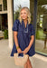 You can never go wrong with classic navy and white polka dots! This dress brings timeless charm with a playful twist. Designed with layered short puff sleeves and elasticated openings, it has just the right amount of volume while staying comfortable and easy to wear. The flattering v-neckline with a collar adds a polished touch, while the elasticated back waist and self-tie detail create a cinched, feminine shape.