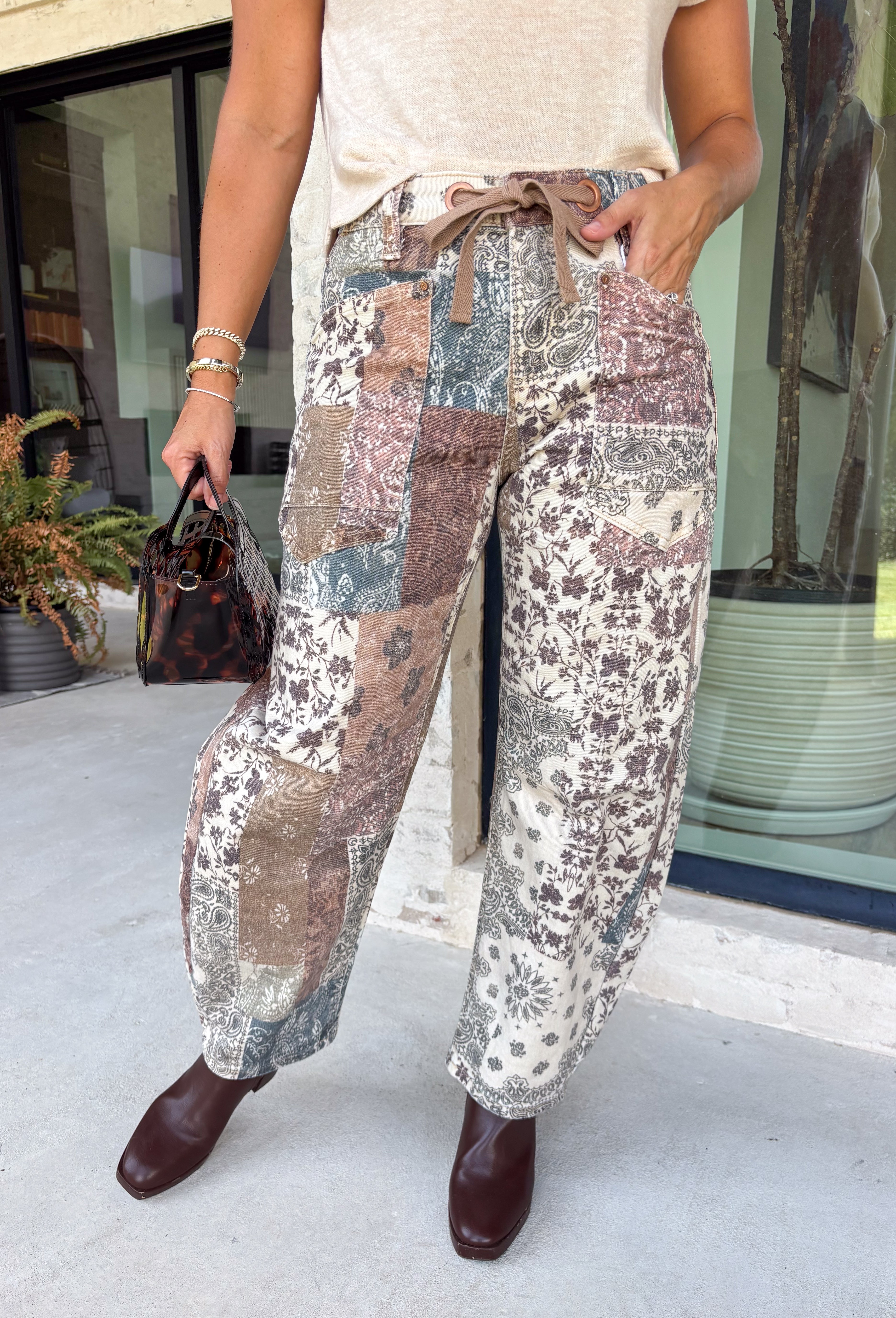 Make room in your denim lineup for these statement-making barrel jeans from Risen. Designed with a neutral mixed paisley print, they bring a vintage-inspired twist to the barrel silhouette you already love. The high-rise fit and cropped length create a flattering shape, while the tie waistband adds an unexpected detail that makes this pair stand out from traditional denim. 