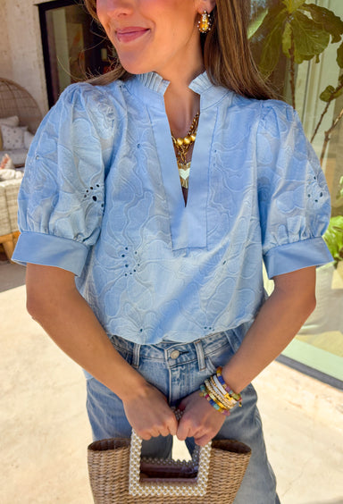 This light blue puff sleeve top by Entro is the perfect blend of classic and charming. Featuring delicate floral embroidery and a pleated band collar with a split v-neckline, it’s full of soft, feminine flair. The short puff sleeves add a playful touch, while the lightweight cotton and full lining keep things comfy and breathable. An easy favorite for everything from brunch dates to springtime strolls!