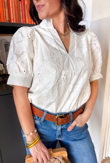 This white puff sleeve top by Entro is the perfect blend of classic and charming. Featuring delicate floral embroidery and a pleated band collar with a split v-neckline, it’s full of soft, feminine flair. The short puff sleeves add a playful touch, while the lightweight cotton and full lining keep things comfy and breathable. An easy favorite for everything from brunch dates to springtime strolls!