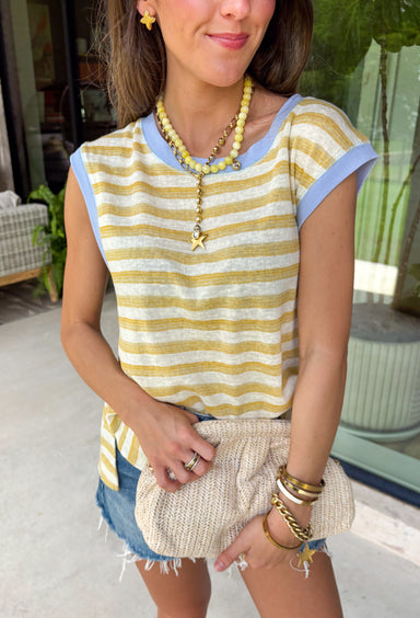 This neutral and mustard stripe top is such a fresh, easy piece for summer! The soft stripe pattern keeps it classic, while the light blue trim along the neckline and sleeves adds the perfect unexpected pop of color. The subtle cap sleeve gives just a little coverage while still keeping it cool and breezy for warm days. Lightweight and easy to style, this is one of those tops you can throw on with denim shorts or white jeans and instantly feel put together. 