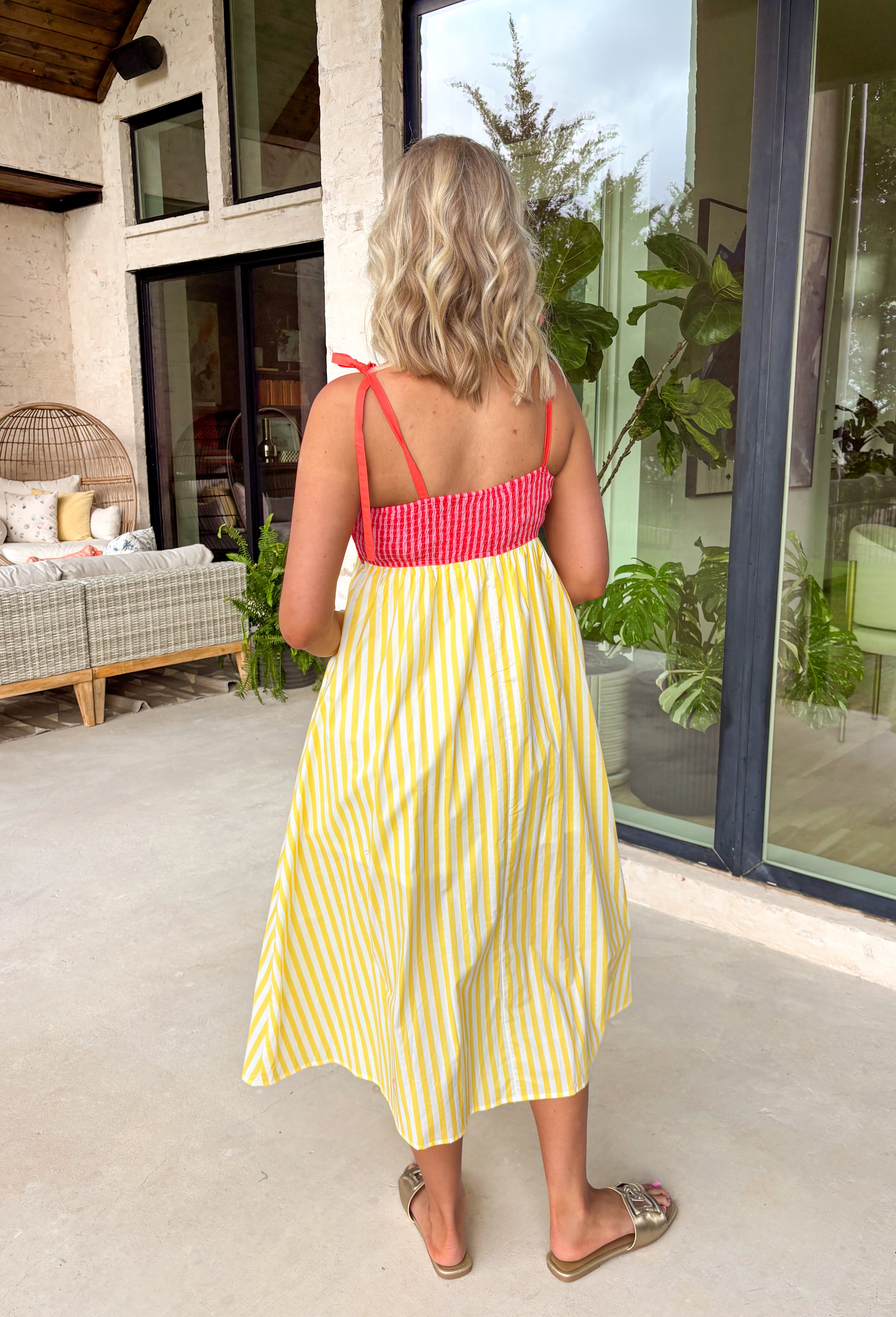 If summer were a dress, this would be it! This sleeveless midi is bursting with cheerful color and playful detail. The pink and red striped bodice features a scalloped neckline that adds the sweetest feminine touch, while the adjustable self-tie straps let you customize the fit just the way you like. The yellow and white skirt brings a bold, sunshine-inspired contrast that feels fresh and fun. 