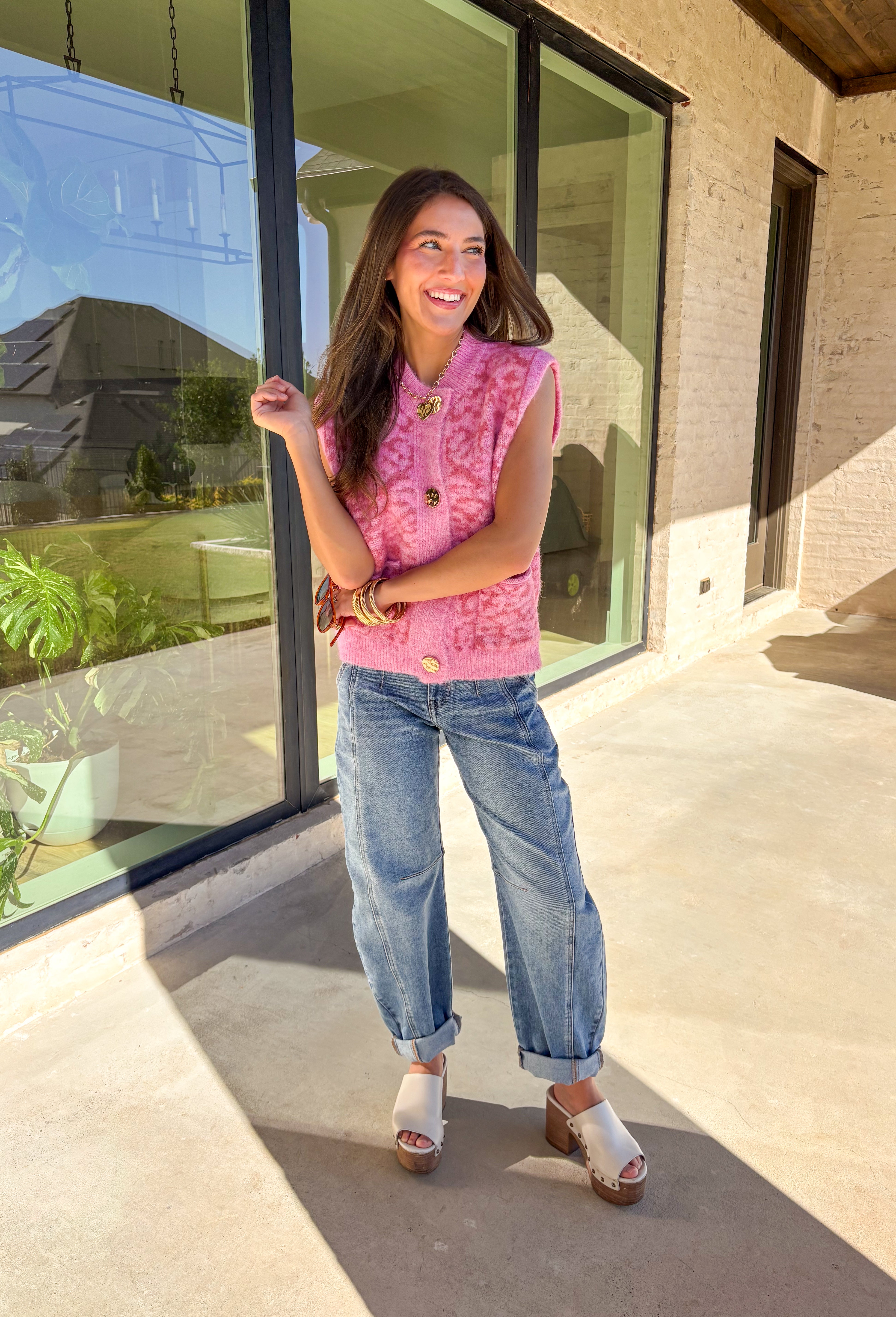 Add a touch of playful charm to your look with this shades-of-pink leopard print sleeveless sweater by &amp;Merci. Crafted in a soft, cozy knit, this piece features shiny gold buttons and two front pockets for a fun, vintage-inspired finish. The sleeveless design makes it perfect for layering or wearing solo during the warmer fall days.