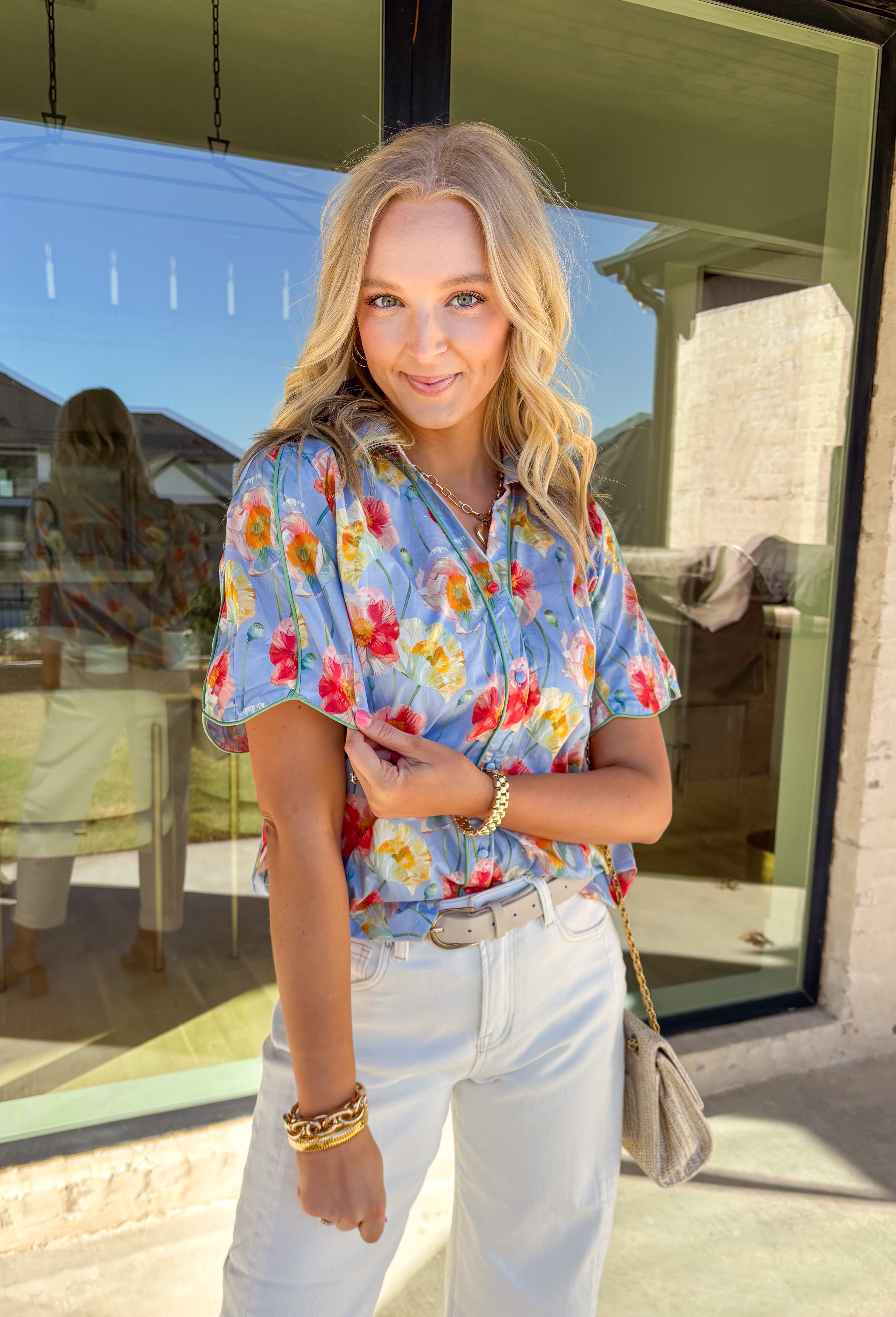Light, cheerful, and made for sunny days, this light blue button-down top by Umgee is a springtime favorite. Featuring a colorful floral print in shades of green, mustard, and pink, this top brings an easy pop of color to your everyday wardrobe. The collared neckline keeps it classic, while the scalloped sleeves add a sweet, feminine touch that feels perfect for the season.