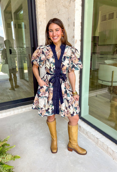 This navy floral dress is giving fall fabulous in the best way. With bold neutral blooms in cream, tan, teal, and brown, it’s the kind of that's perfect for any special occasion. The button-down design and matching self-tie waist keep things polished, while puff sleeves and navy trim down the front add a little extra charm.&nbsp;