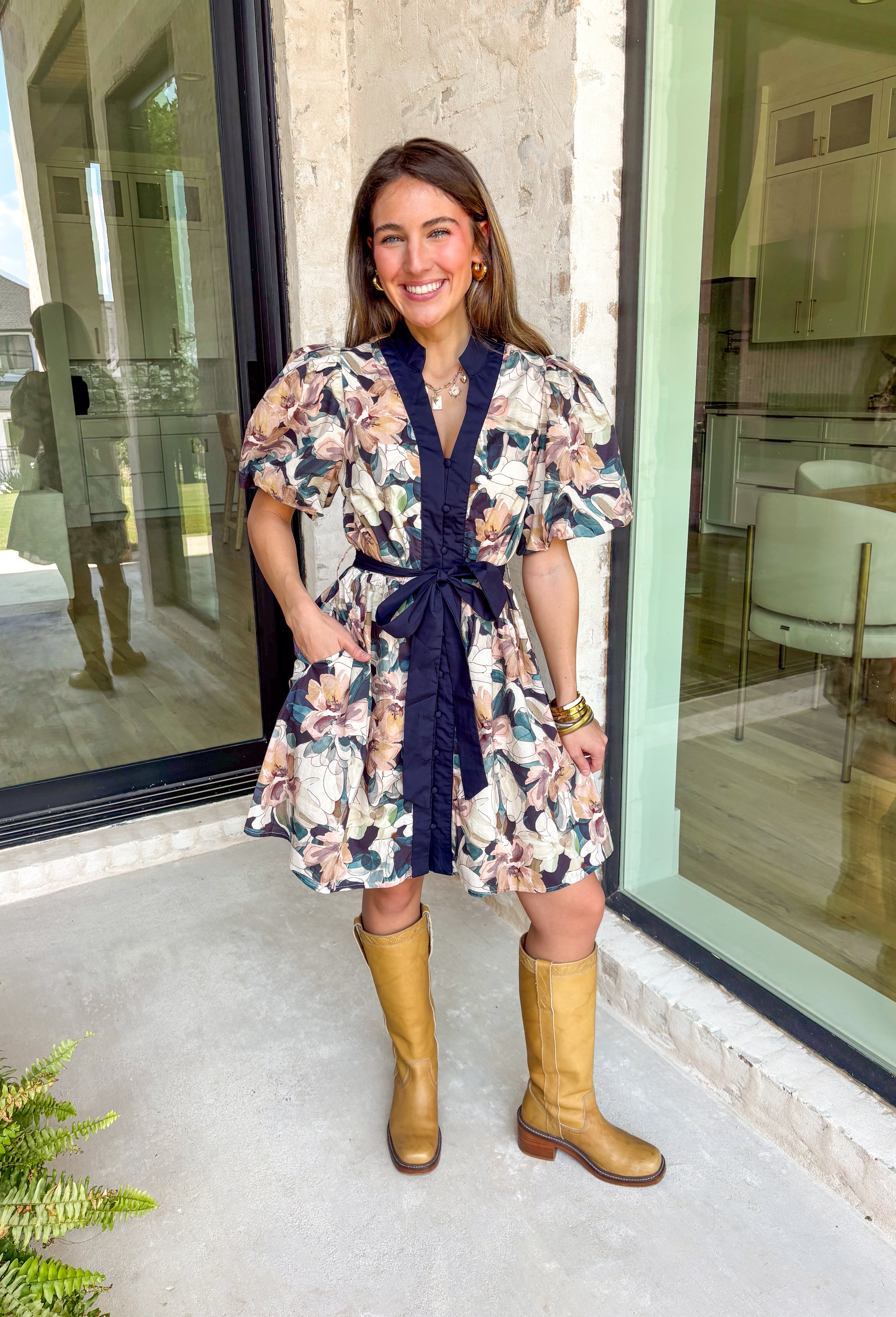 This navy floral dress is giving fall fabulous in the best way. With bold neutral blooms in cream, tan, teal, and brown, it’s the kind of that's perfect for any special occasion. The button-down design and matching self-tie waist keep things polished, while puff sleeves and navy trim down the front add a little extra charm.&nbsp;