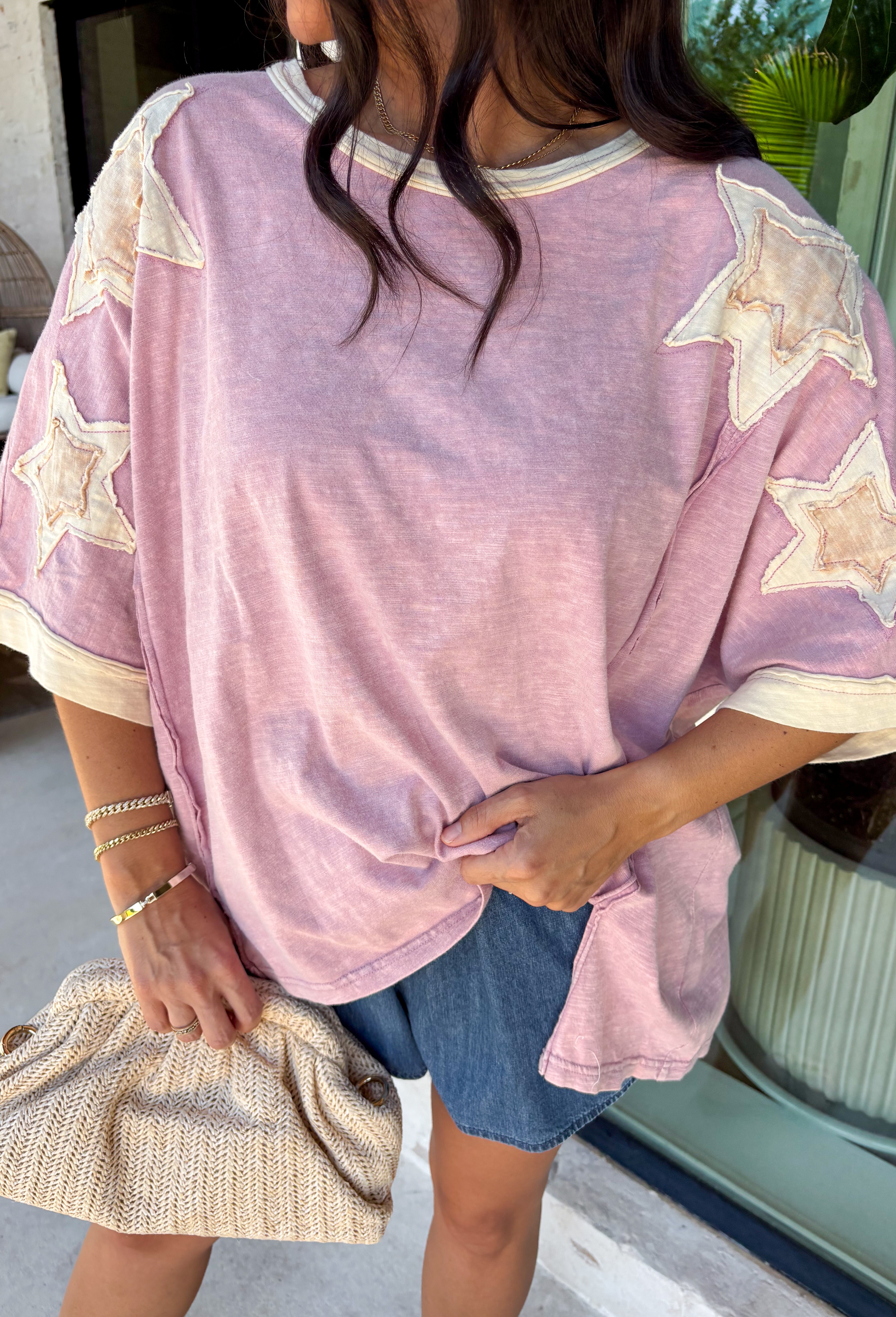This mauve star print tee is the perfect mix of casual and cute for summer days! The soft mauve base paired with cream stars gives it a playful, laid-back vibe, while the embroidered details add that extra touch that makes it feel special. The contrast cream neckline and sleeves keep it fresh, and the exposed hem in the back adds a subtle, cool detail. Made from breathable cotton, it’s an easy throw-on piece for everything from errands to relaxed weekends. 