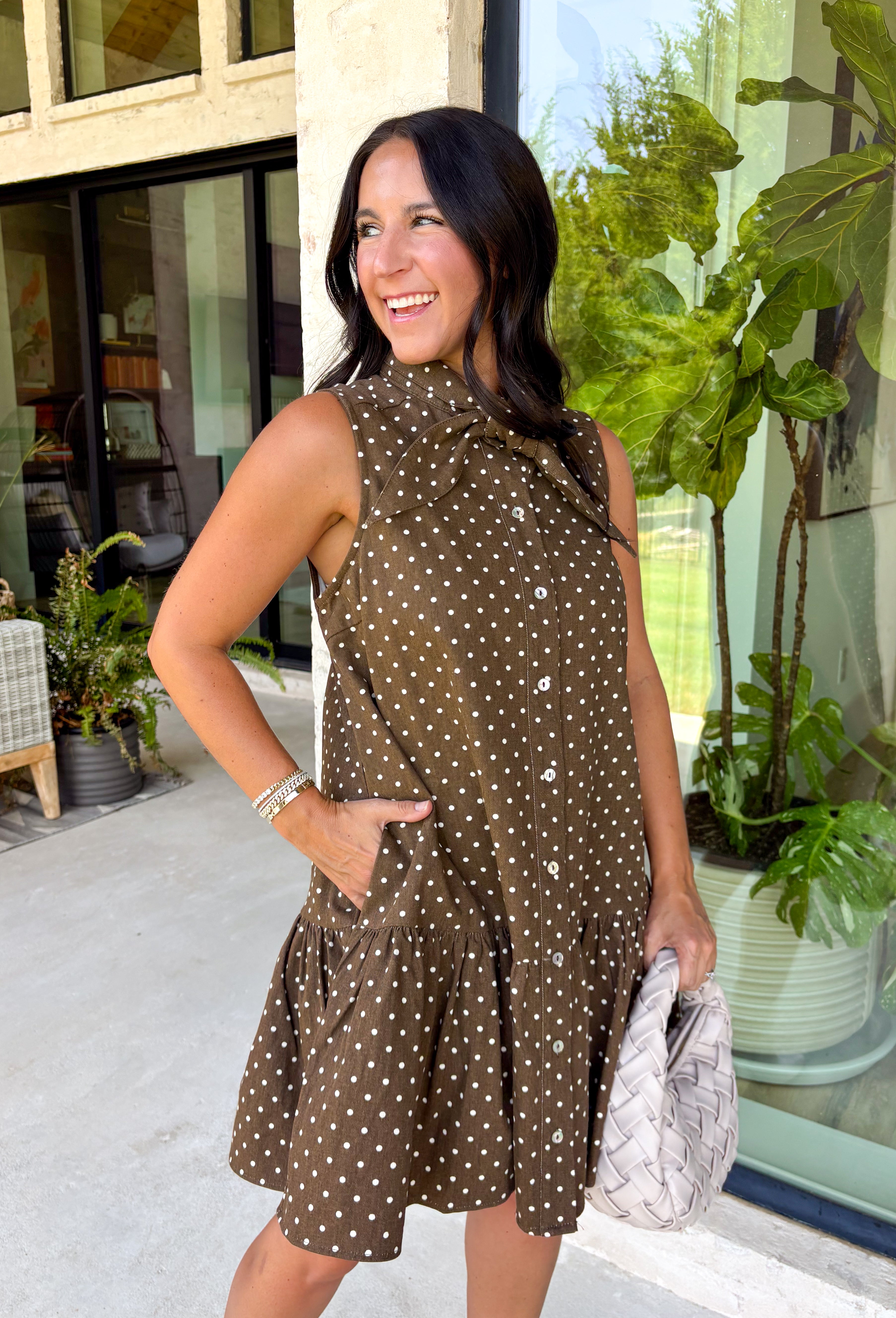 Timeless style meets feminine charm in this adorable mini dress from Entro. Crafted from soft brown denim with a classic off-white polka dot print, this sleeveless dress is full of thoughtful details you'll love. The attached neck tie adds a polished, vintage-inspired touch, while the button-front design creates an effortlessly classic silhouette. Finished with side pockets and breathable cotton fabric, this versatile dress is perfect for everything from brunch dates to weekend adventures all season long.