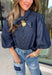 Give your denim collection a fresh twist with this dark wash blouse from Entro. The lightweight cotton fabric keeps it comfortable and easy to wear, while the rich dark wash feels right at home as fall transitions into winter. A high neckline with a self-tie detail adds a pretty focal point, complemented by gold button detailing along the front. The ¾ puff sleeves bring a little volume to the silhouette without making it feel overly dressy. 