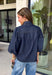Give your denim collection a fresh twist with this dark wash blouse from Entro. The lightweight cotton fabric keeps it comfortable and easy to wear, while the rich dark wash feels right at home as fall transitions into winter. A high neckline with a self-tie detail adds a pretty focal point, complemented by gold button detailing along the front. The ¾ puff sleeves bring a little volume to the silhouette without making it feel overly dressy. 