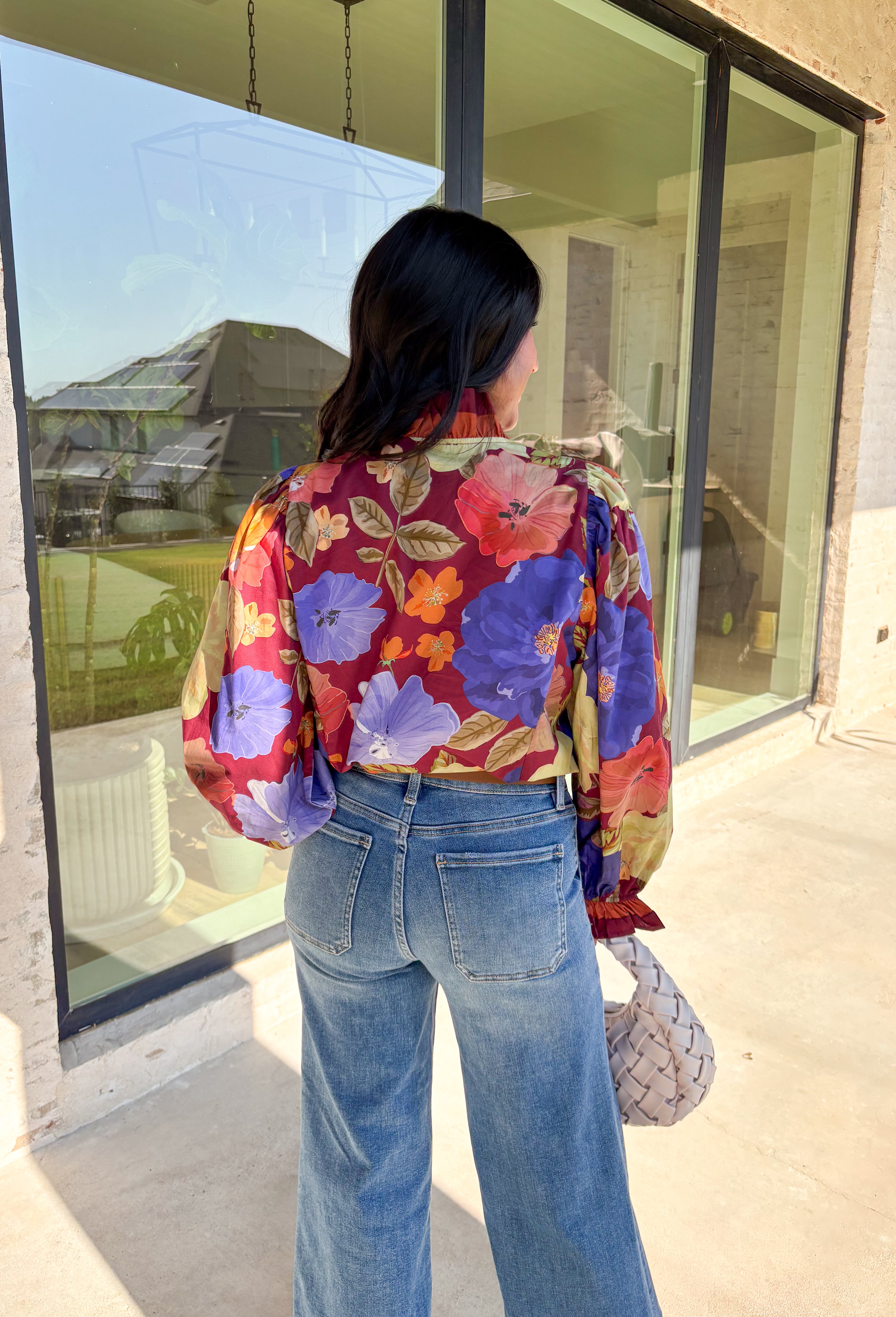 Romantic details make this burgundy floral top a standout for fall. The long sleeves give it an easy, relaxed fit, while the pleated ruffle trim along the neckline and placket adds movement and charm. Designed with a mix of autumn tones in the print, it’s a lightweight piece that’s as versatile as it is stylish. Perfect for workdays, casual weekends, or seasonal gatherings, this blouse transitions seamlessly from day to night.