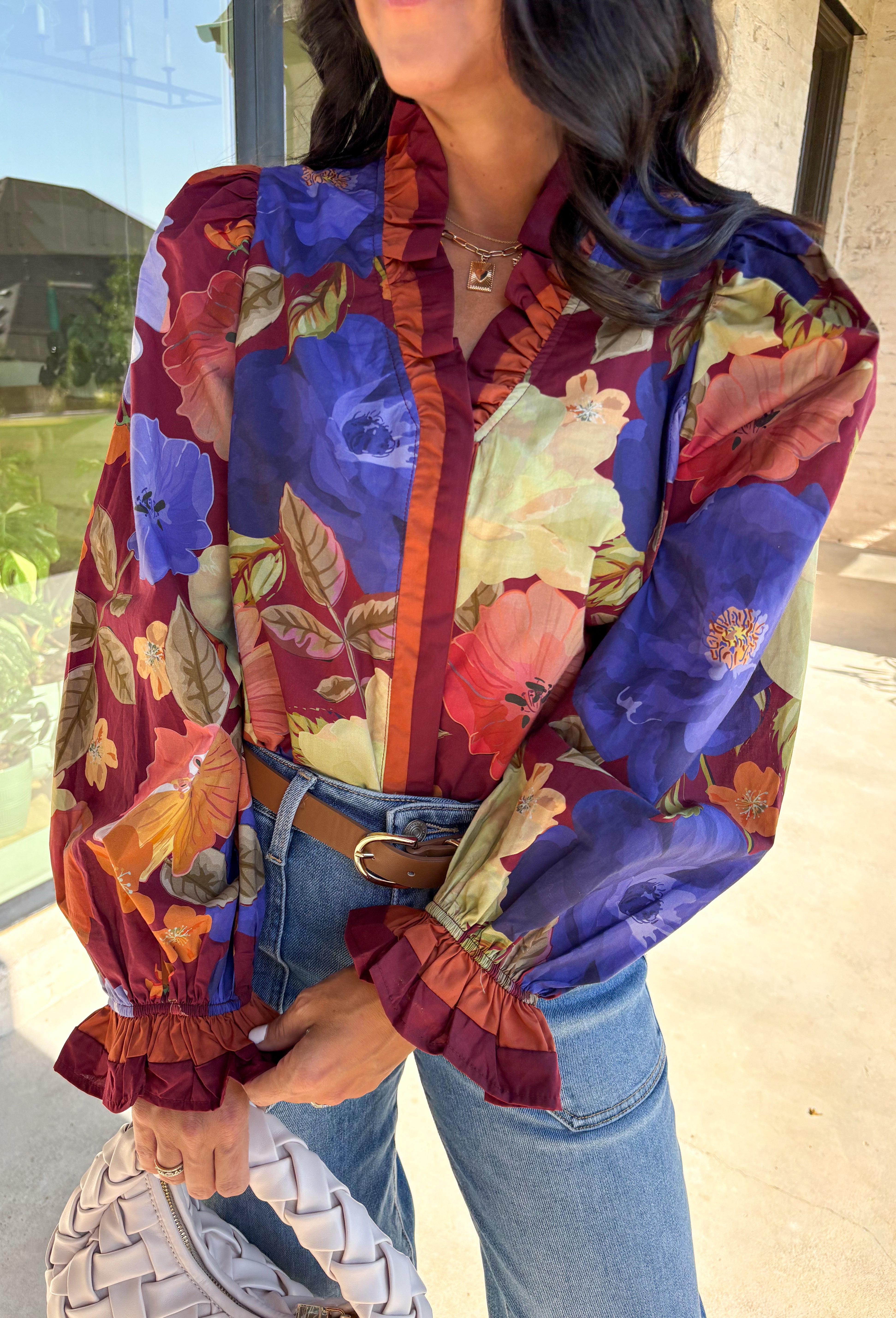 Romantic details make this burgundy floral top a standout for fall. The long sleeves give it an easy, relaxed fit, while the pleated ruffle trim along the neckline and placket adds movement and charm. Designed with a mix of autumn tones in the print, it’s a lightweight piece that’s as versatile as it is stylish. Perfect for workdays, casual weekends, or seasonal gatherings, this blouse transitions seamlessly from day to night.