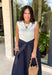 This sleeveless midi dress is the definition of effortless summer style! With its white top and navy skirt design, it gives you that perfectly layered look without any extra effort. The self-tie belt with white threading detail adds a flattering touch at the waist, while the matching detail along the hem pulls everything together beautifully. Lightweight, lined, and finished with side pockets, it’s as practical as it is polished. 