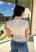 Fresh, fun, and perfect for spring styling, this oatmeal and off-white striped mock neck top by Entro is an easy favorite for the season. Designed with cap sleeves and a lightweight feel, it’s great for warm days while still offering a little extra coverage. The cropped length gives it a modern, on-trend look that pairs perfectly with high-waisted denim, skirts, or trousers.