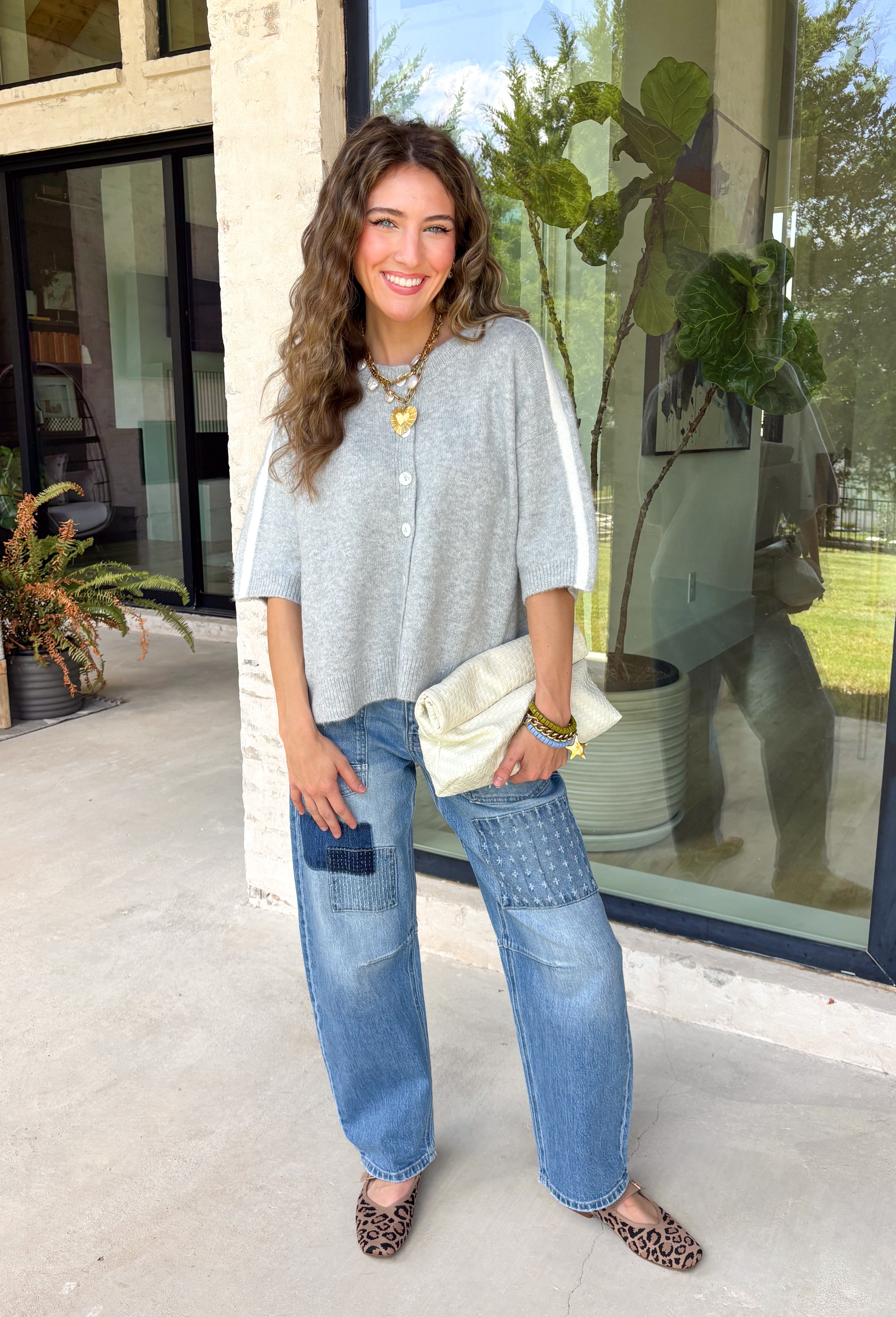This light grey cardigan is the perfect layering piece for the season ahead! The soft knit and timeless button down design make it a wardrobe staple you'll reach for again and again. A crisp white stripe along the sleeves adds a subtle varsity-inspired touch, while the ribbed hem and sleeve cuffs create a polished finish. Wear it buttoned as a sweater or layered over your favorite basics for endless styling possibilities.