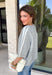 This light grey cardigan is the perfect layering piece for the season ahead! The soft knit and timeless button down design make it a wardrobe staple you'll reach for again and again. A crisp white stripe along the sleeves adds a subtle varsity-inspired touch, while the ribbed hem and sleeve cuffs create a polished finish. Wear it buttoned as a sweater or layered over your favorite basics for endless styling possibilities.