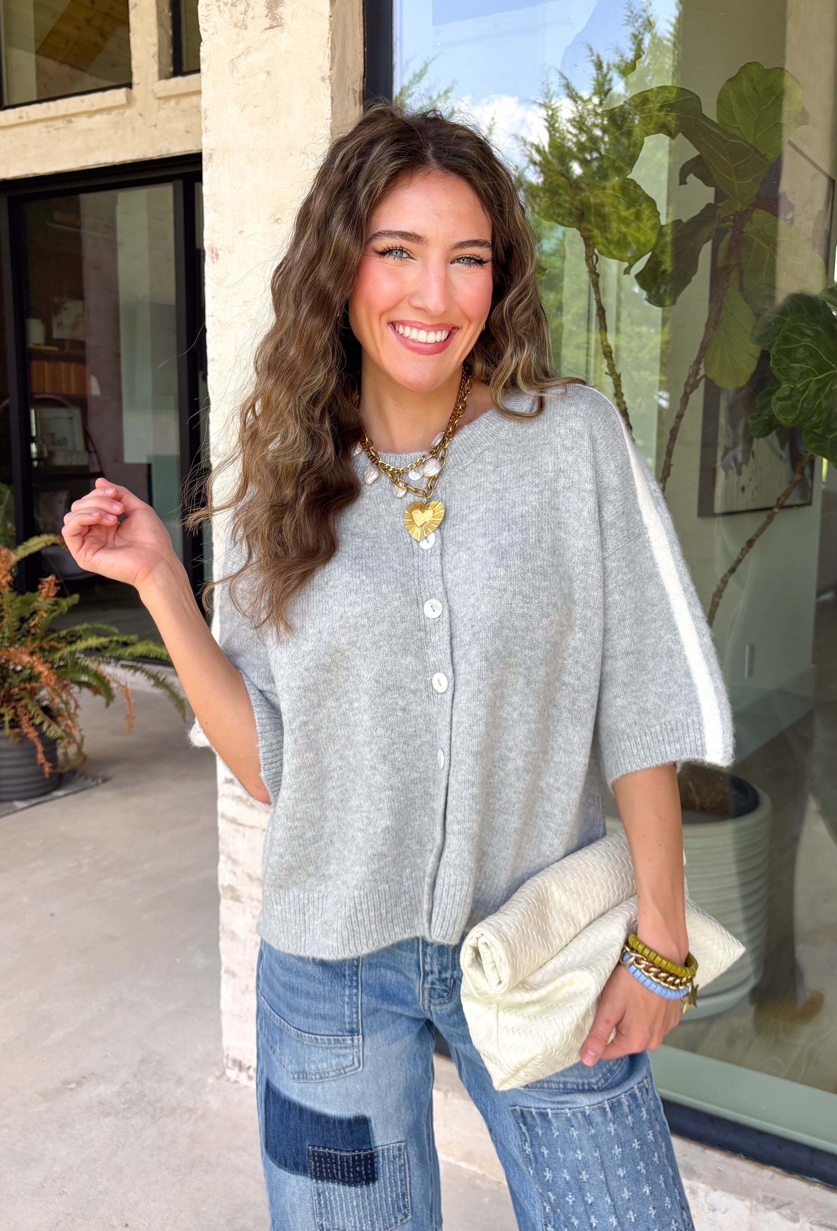 This light grey cardigan is the perfect layering piece for the season ahead! The soft knit and timeless button down design make it a wardrobe staple you'll reach for again and again. A crisp white stripe along the sleeves adds a subtle varsity-inspired touch, while the ribbed hem and sleeve cuffs create a polished finish. Wear it buttoned as a sweater or layered over your favorite basics for endless styling possibilities.