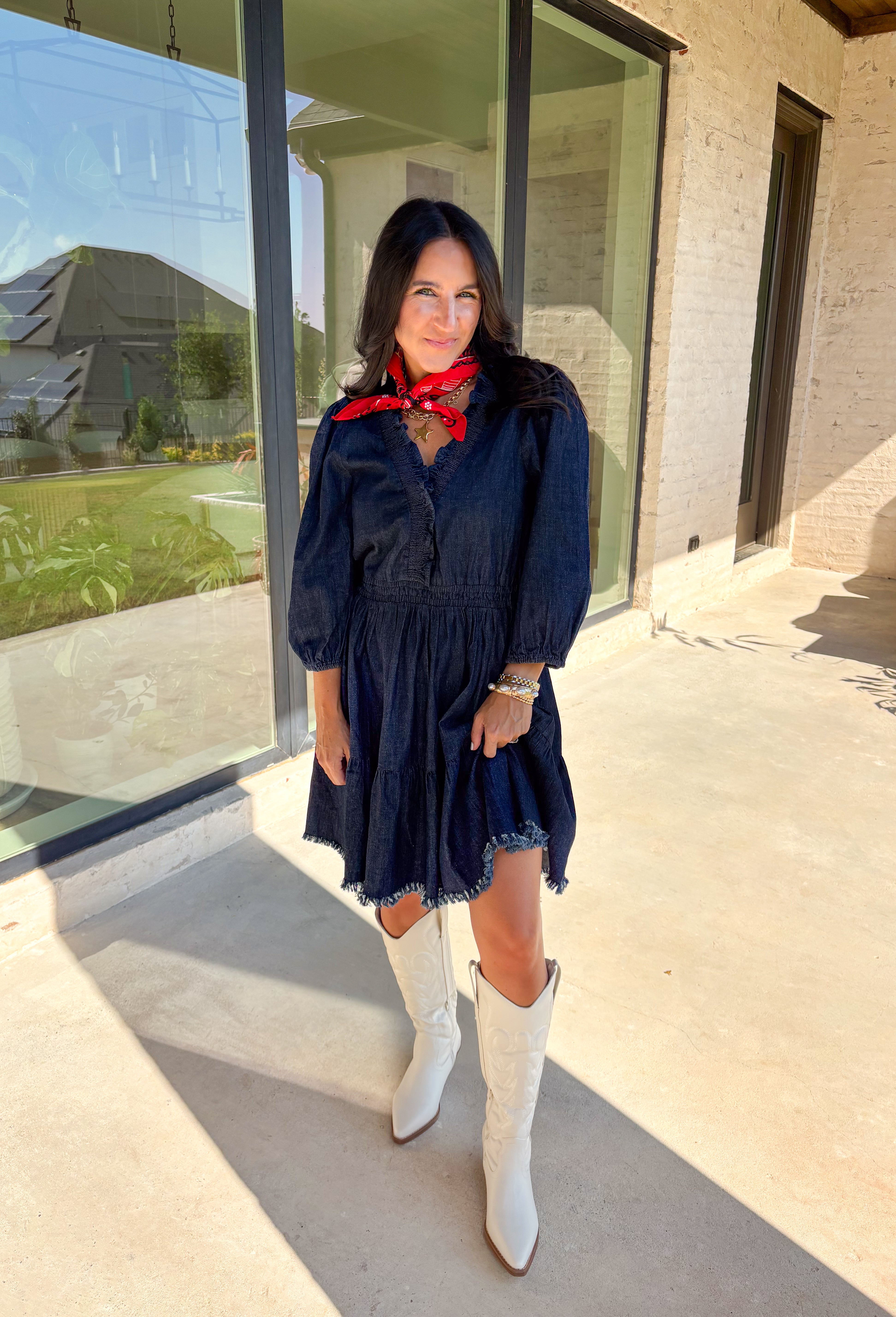 Denim with a feminine twist—this long sleeve dress is a seasonal must-have. Designed in a rich dark wash, it features a flattering smocked waist and a raw edge hem that adds a casual, lived-in feel. The ruffle trim softens the look, while elastic cuff sleeves keep it comfortable and easy to wear. Made from a cotton blend, it’s lightweight enough to layer and cozy enough to wear on its own for crisp fall days.