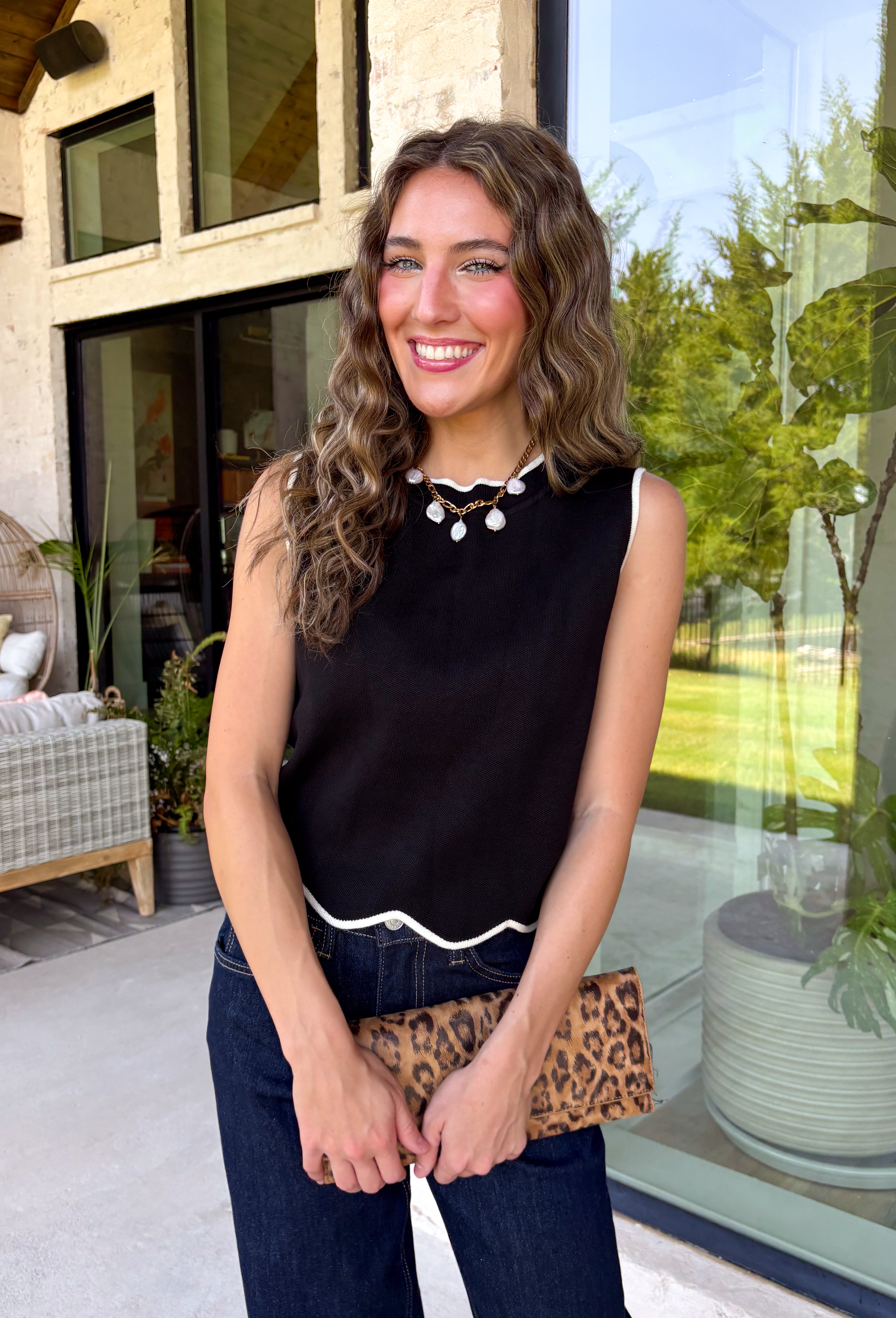 Timeless, polished, and endlessly versatile, this sweater tank from Day + Moon is a piece you'll reach for season after season. Designed in a classic black knit, it features beautiful ivory contrast trim along the neckline and arm openings for a refined touch. The ivory scalloped hem adds the perfect feminine finish, making this sleeveless sweater just as pretty worn on its own as it is layered under jackets and cardigans.