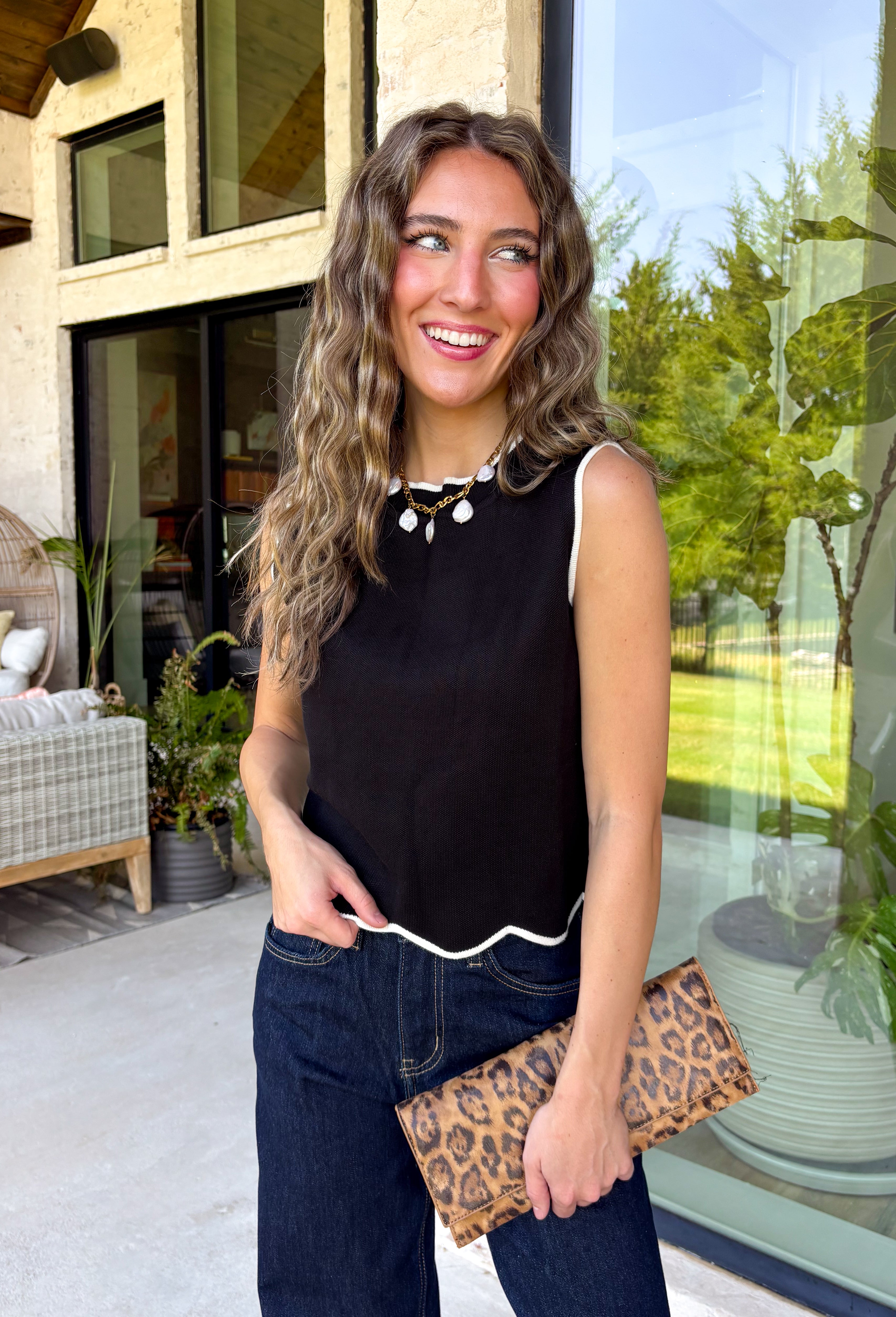 Timeless, polished, and endlessly versatile, this sweater tank from Day + Moon is a piece you'll reach for season after season. Designed in a classic black knit, it features beautiful ivory contrast trim along the neckline and arm openings for a refined touch. The ivory scalloped hem adds the perfect feminine finish, making this sleeveless sweater just as pretty worn on its own as it is layered under jackets and cardigans.
