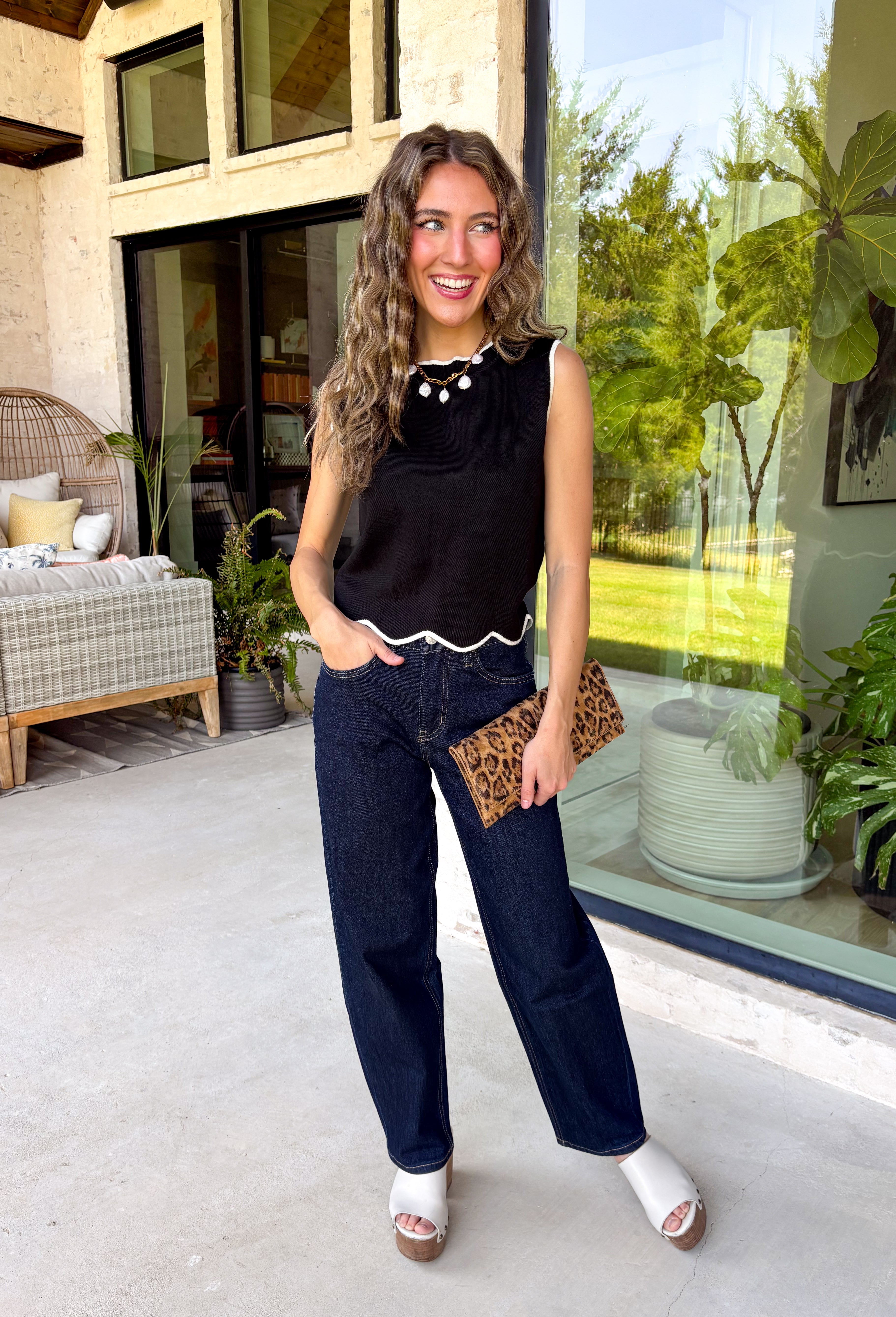 Timeless, polished, and endlessly versatile, this sweater tank from Day + Moon is a piece you'll reach for season after season. Designed in a classic black knit, it features beautiful ivory contrast trim along the neckline and arm openings for a refined touch. The ivory scalloped hem adds the perfect feminine finish, making this sleeveless sweater just as pretty worn on its own as it is layered under jackets and cardigans.