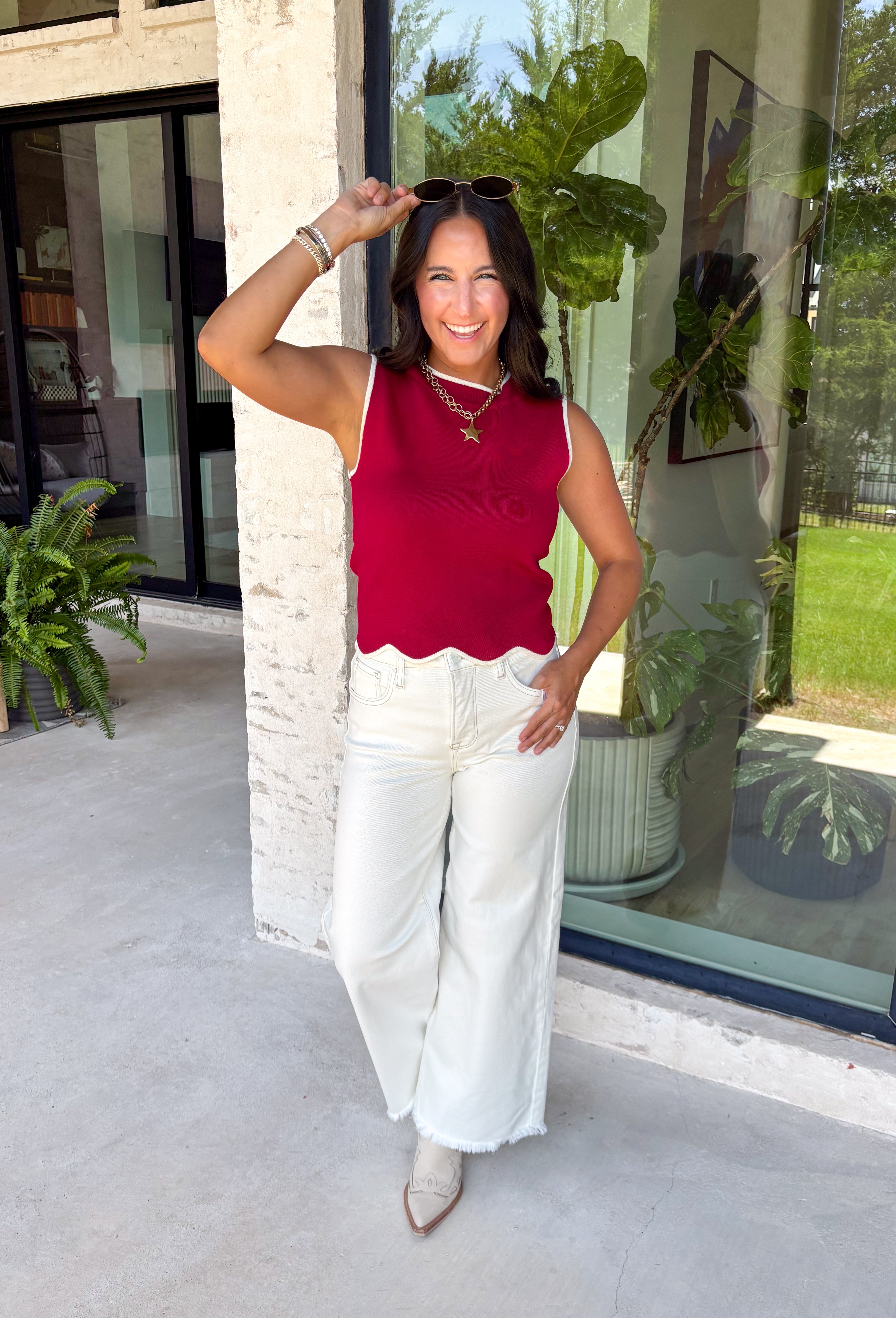 Classic with a touch of charm, this crimson sweater tank is made for the season ahead. The rich autumn hue is beautifully accented with crisp white trim and a delicate scalloped hem, creating a timeless look that's both polished and playful. Crafted from a soft sweater knit, it's perfect for layering under your favorite blazer, denim jacket, or cardigan as the temperatures begin to cool. 